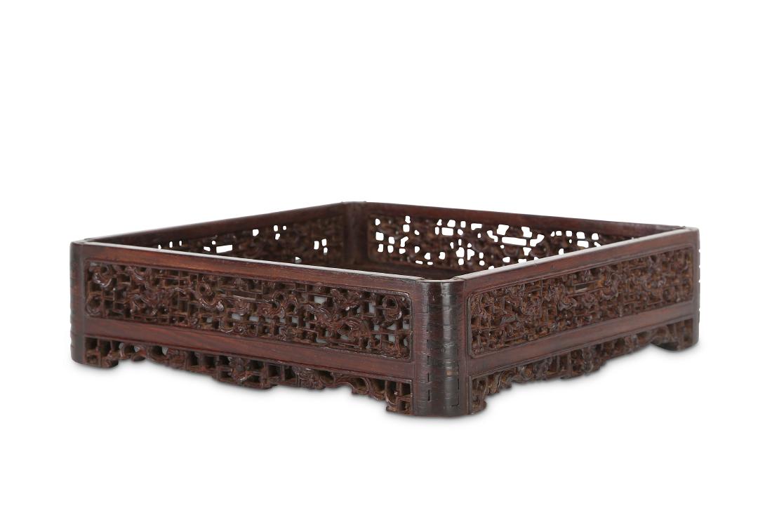A CHINESE INSCRIBED HONGMU TRAY.: A CHINESE INSCRIBED HONGMU TRAY. Qing Dynasty, 19th Century. The square base carved to two corners with short inscriptions reading Ming Ming Shi Jiu Nian Zao, Ping Cheng and Gu Shu Fa Yun Pu Er Wen Da