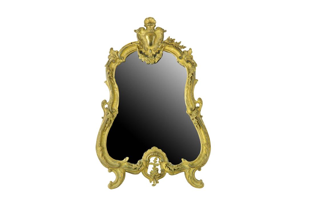 A gilt metal Rococo style mirror of shaped outline and (1 of 2)