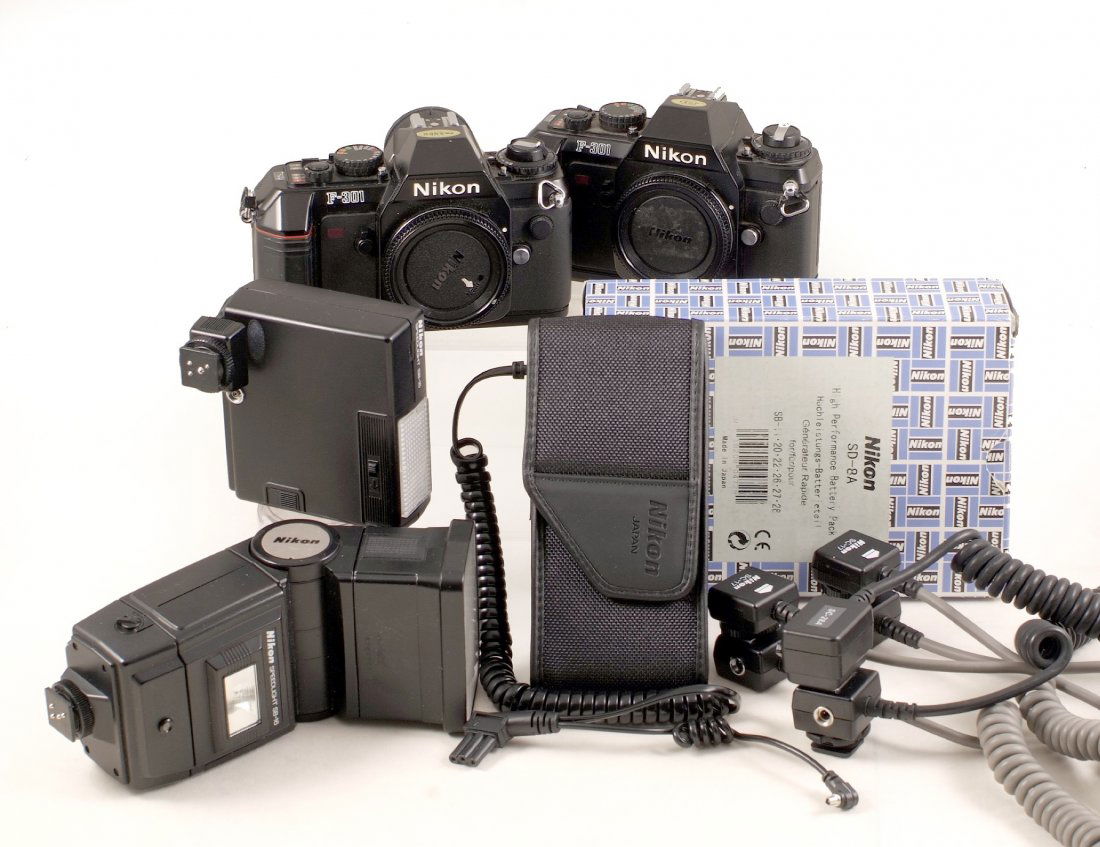 A Pair of Nikon F-301 Camera Bodies, plus Flash: A Pair of Nikon F-301 Camera Bodies, plus Flash Equipment. Comprising two working F-301 bodies, working SB-16 and SB-15 Speedlites, two Nikon SC-17 and a SC-28A off-camera cables. All with signs of no