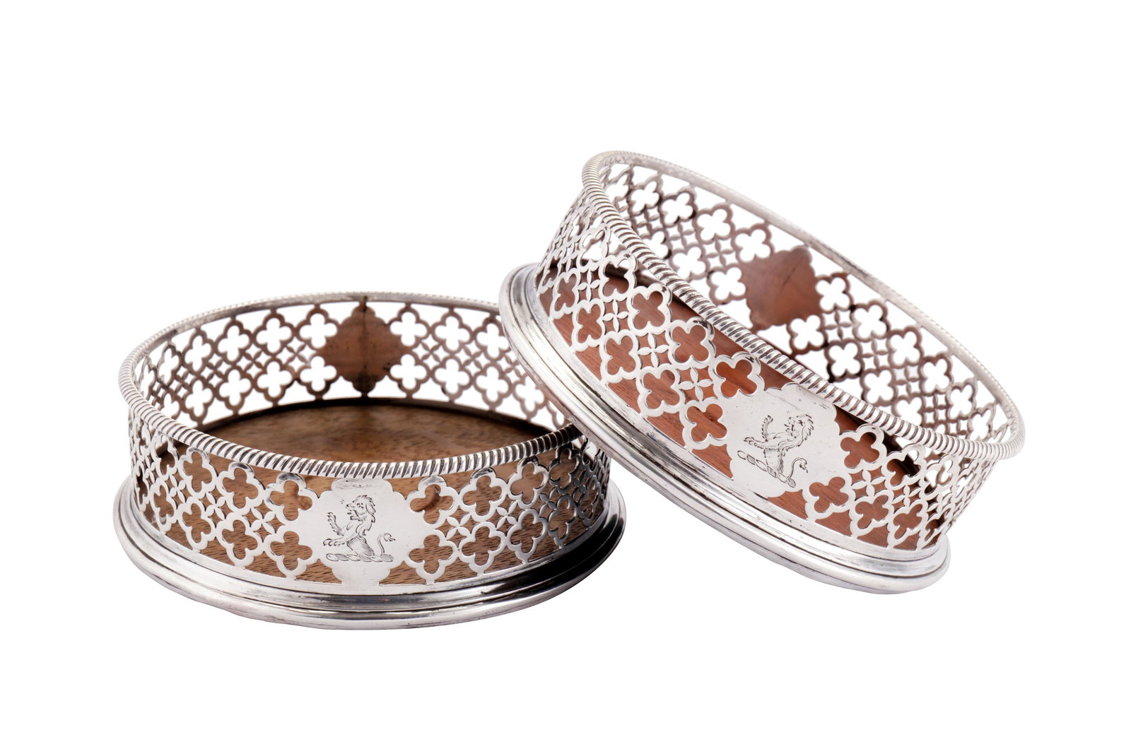 A pair of George III sterling silver wine coasters,: A pair of George III sterling silver wine coasters, London 1769 by Edward Lowe Each of circular form with a gadrooned rim, the sides with pierced decoration of gothic tracery quatrefoils. Cartouches t