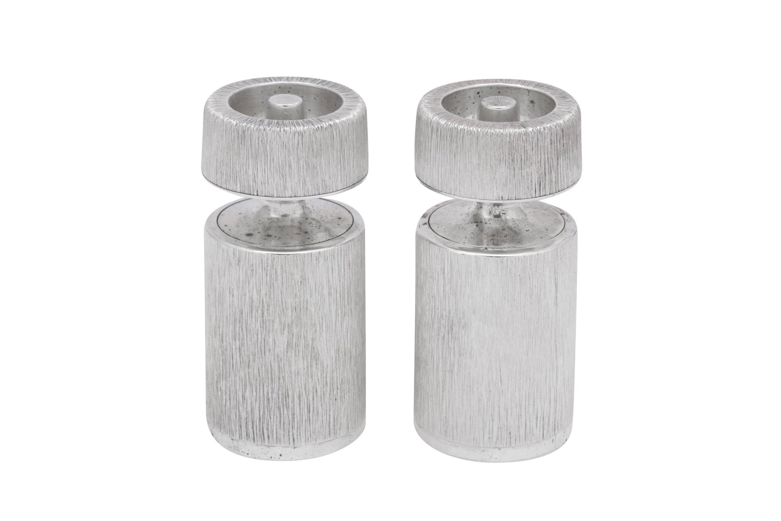 A pair of Elizabeth II modernist sterling silver salt: A pair of Elizabeth II modernist sterling silver salt and pepper grinders, London 1998 by Gerald Benney (1930-2008) Of cylindrical form, with textured decoration. The turning section with either a tex