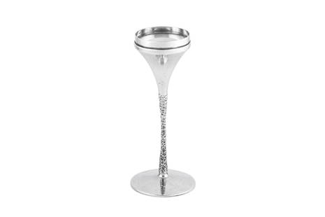 An Elizabeth II modernist sterling silver candlestick, London 1973 by Stuart Devlin (1931-2018): An Elizabeth II modernist sterling silver candlestick, London 1973 by Stuart Devlin (1931-2018) Circular foot with a textured stem leading to a conical capital. Fully marked underneath. Height ��