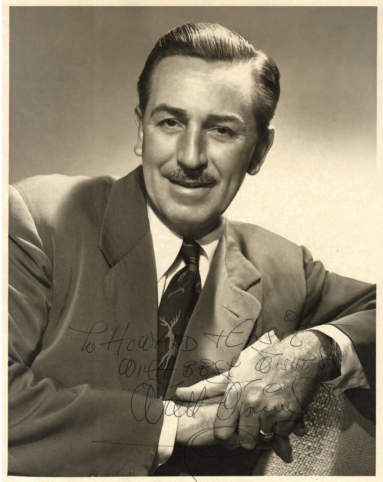 Disney (Walt): Disney (Walt) Impressive matte finish portrait photograph of Walt Disney in a three-quarter length pose, boldly signed and inscribed across the lower portion of the image in black ball point pen "To H