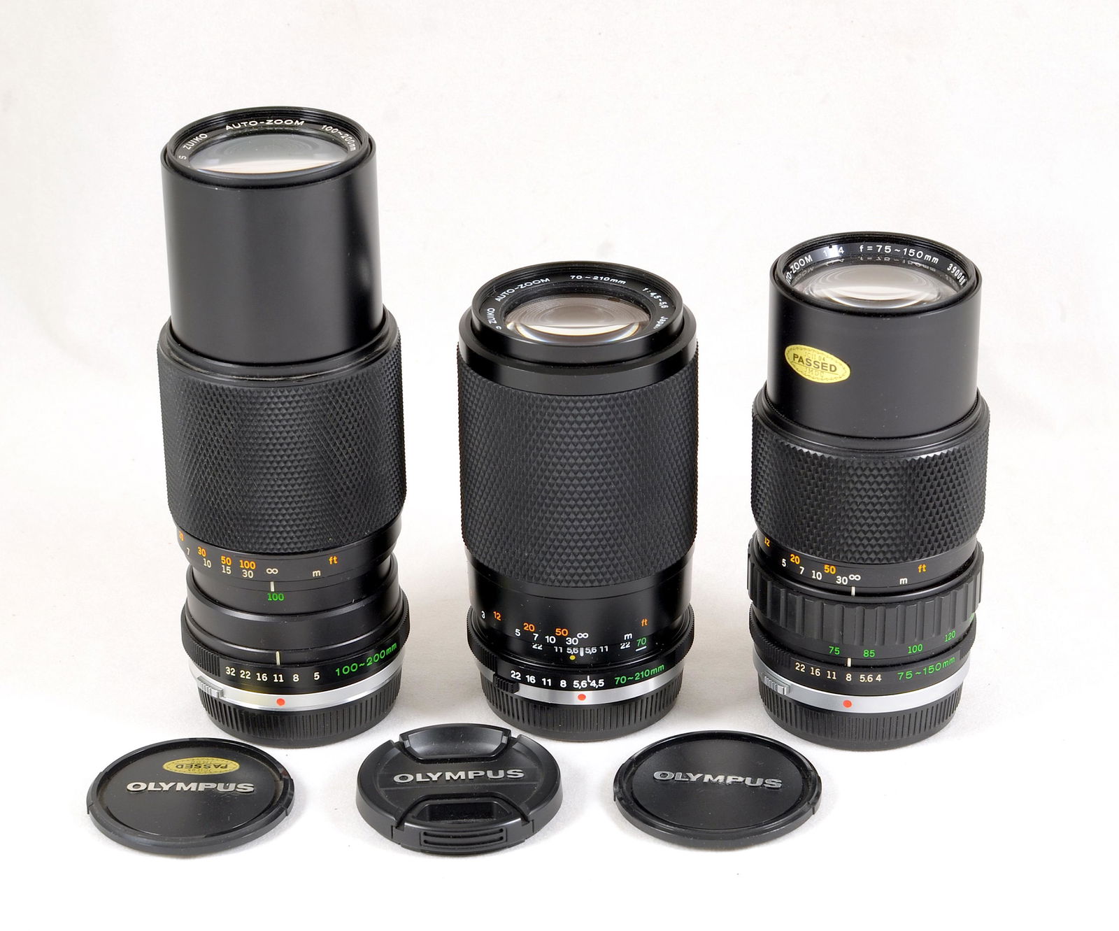 A Group of Three Olympus OM Zoom Lenses.: Comprising 70-210mm f4.5; 75-150mm f4 and a 100-200mm f5. Each with some internal dust, otherwise optics are good, with signs of light use. Provenance: The John Foster Olympus Collection