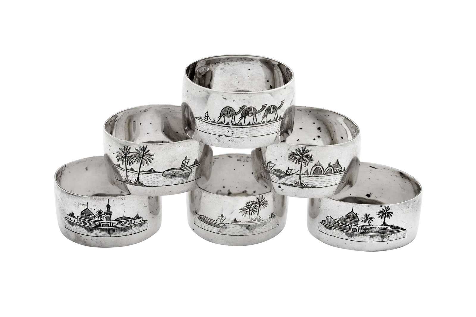 A set of six mid-20th century Iraqi silver and niello napkin rings, Basra circa 1940: A set of six mid-20th century Iraqi silver and niello napkin rings, Basra circa 1940 each of oval form with engraved decoration of typical scenes. (6) Weight – 123 grams / 3.95 ozt