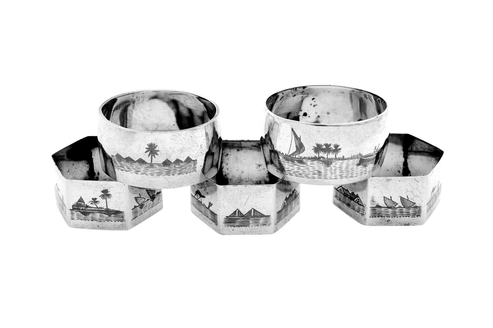 A mixed group of early 20th century silver and niello napkin rings, Omara circa 1930: A mixed group of early 20th century silver and niello napkin rings, Omara circa 1930 Three of hexagonal form, nielloed with the tomb of ezra, the Taq Kasra (Ruins of Ctesiphon), the great pyramids of