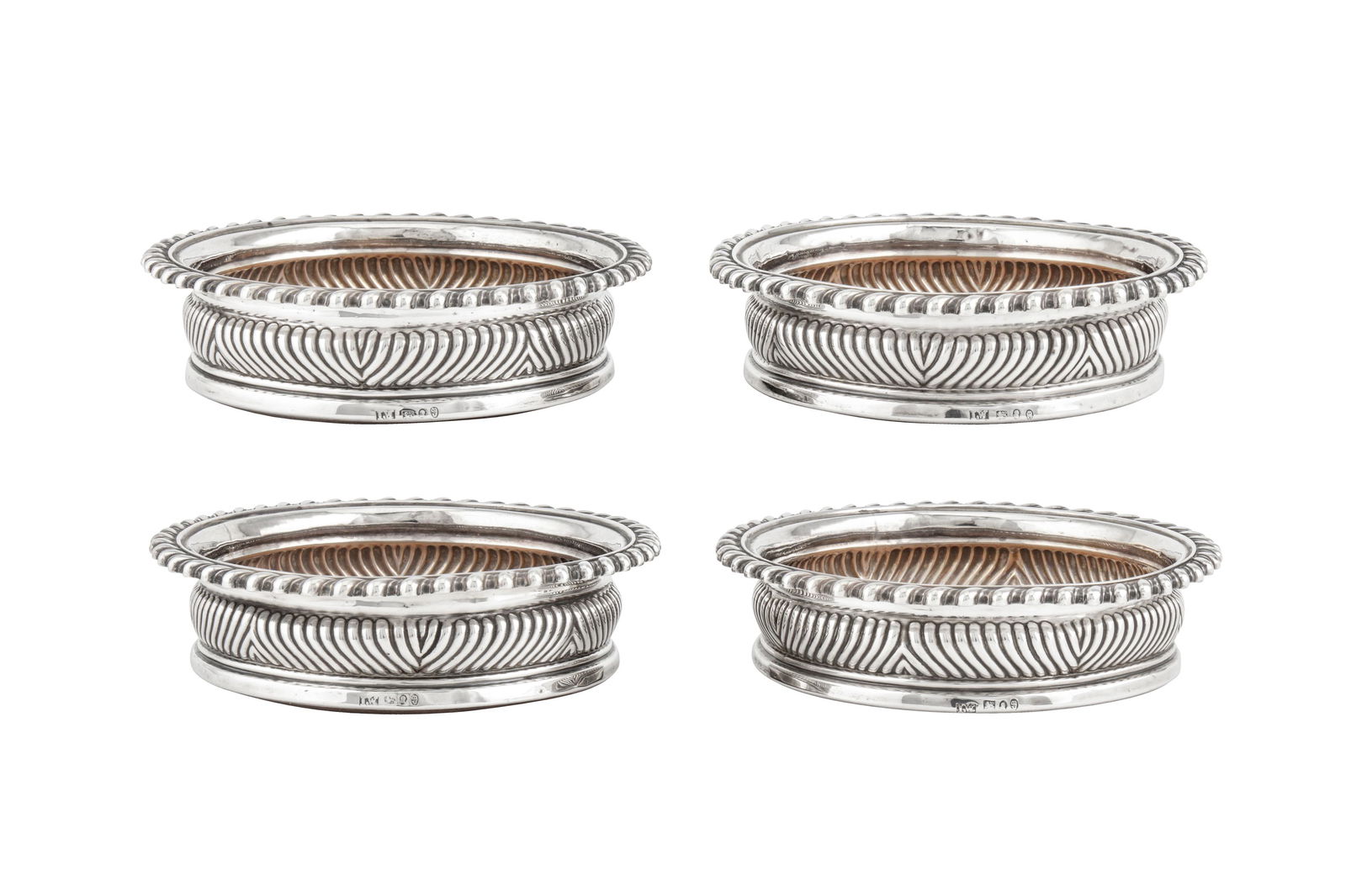 A set of four George III sterling silver wine coasters, Sheffield 1819 by John Watson and Co: A set of four George III sterling silver wine coasters, Sheffield 1819 by John Watson and Co each of circular form with embowed sides and gadrooned rims, the sides with spirally fluted decoration. Eac