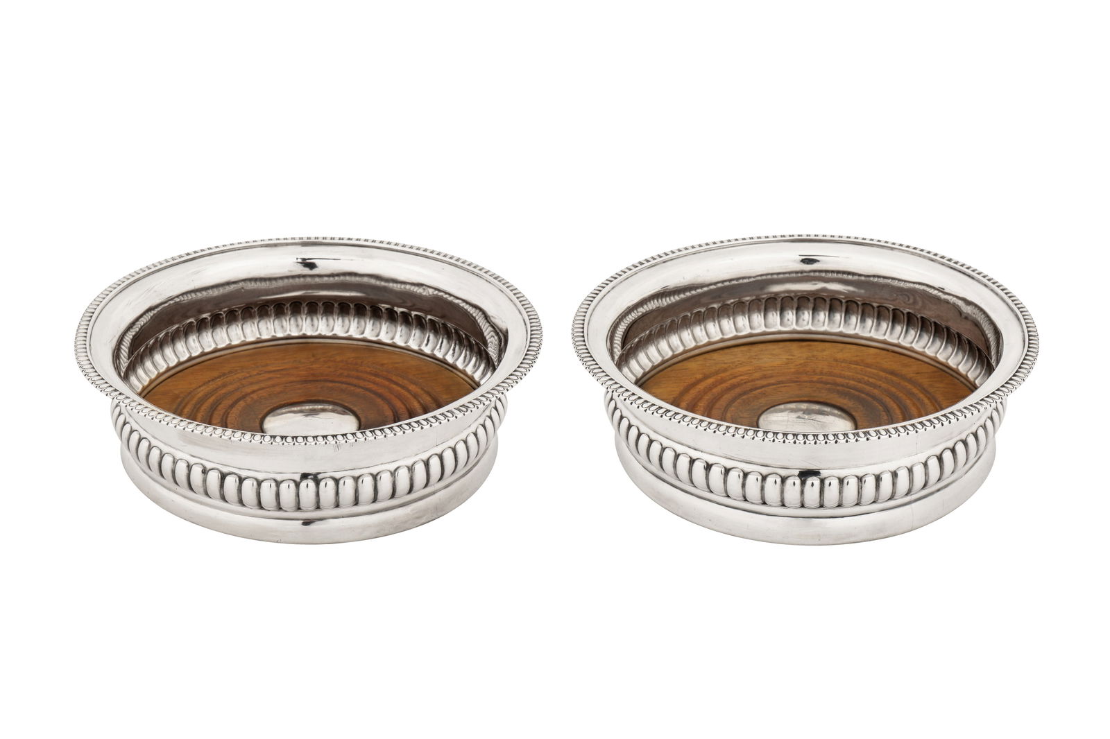 A pair of George III provincial sterling silver wine coasters, Newcastle circa 1815 by John: A pair of George III provincial sterling silver wine coasters, Newcastle circa 1815 by John Robertson II and John Walton (active 1811-20) Of circular form with bombe sides with embossed decoration and