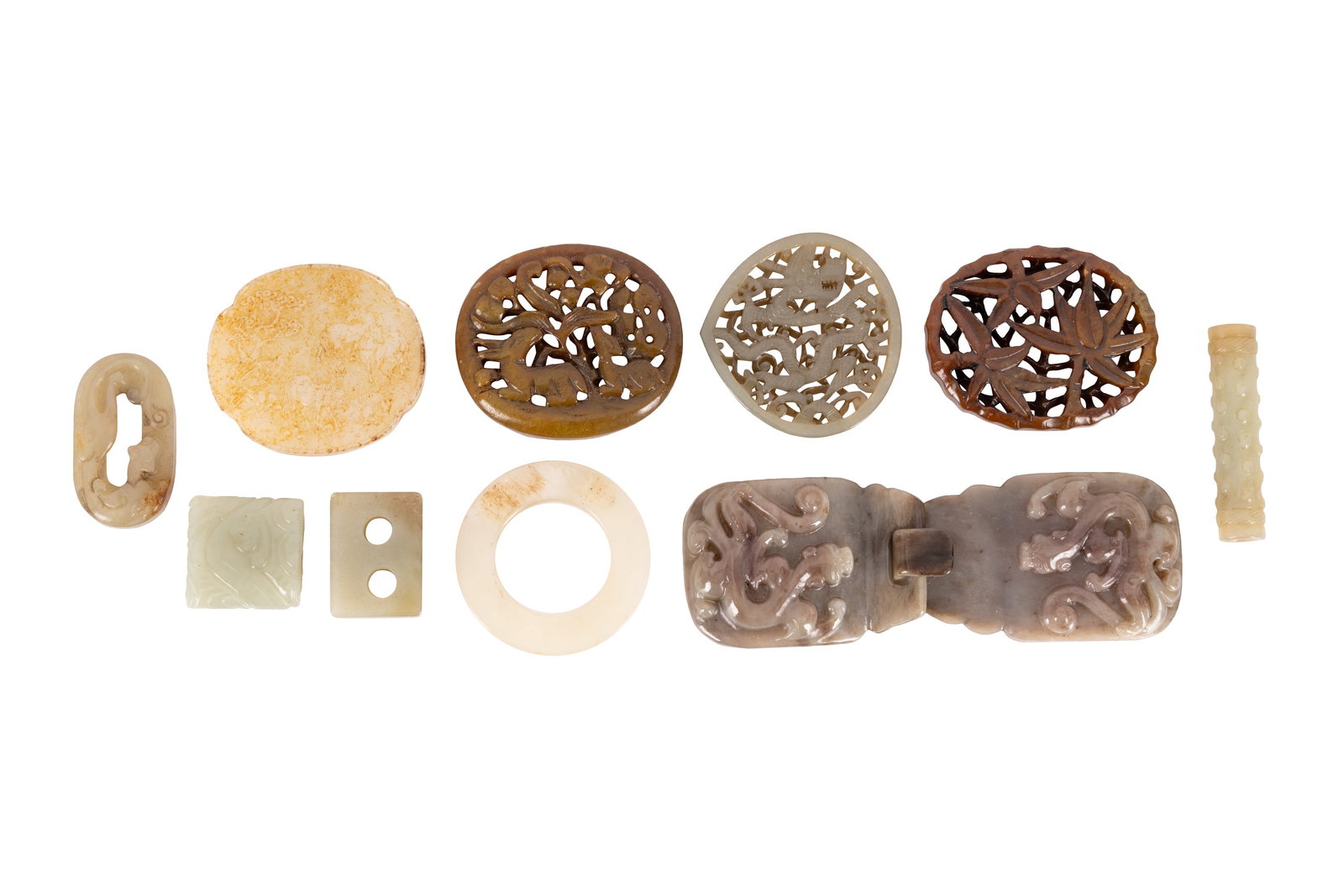 A GROUP OF CHINESE JADE CARVINGS: A GROUP OF CHINESE JADE CARVINGS, comprising a belt buckle together with several reticulated plaques and archaistic carvings, 3 - 7cm long (11)