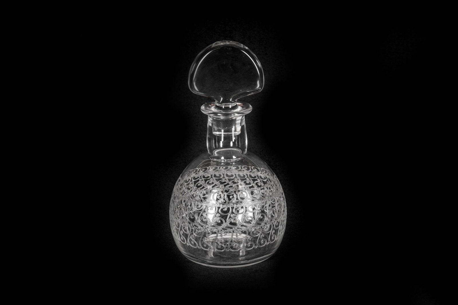 A BACCARAT 'ROHAN' CRYSTAL DECANTER: A BACCARAT 'ROHAN' CRYSTAL DECANTER, circa 1935, with a fan-shaped stopper and acid-etched foliate decoration to the spherical body, acid etched mark to the base, together with a Baccarat faceted crys