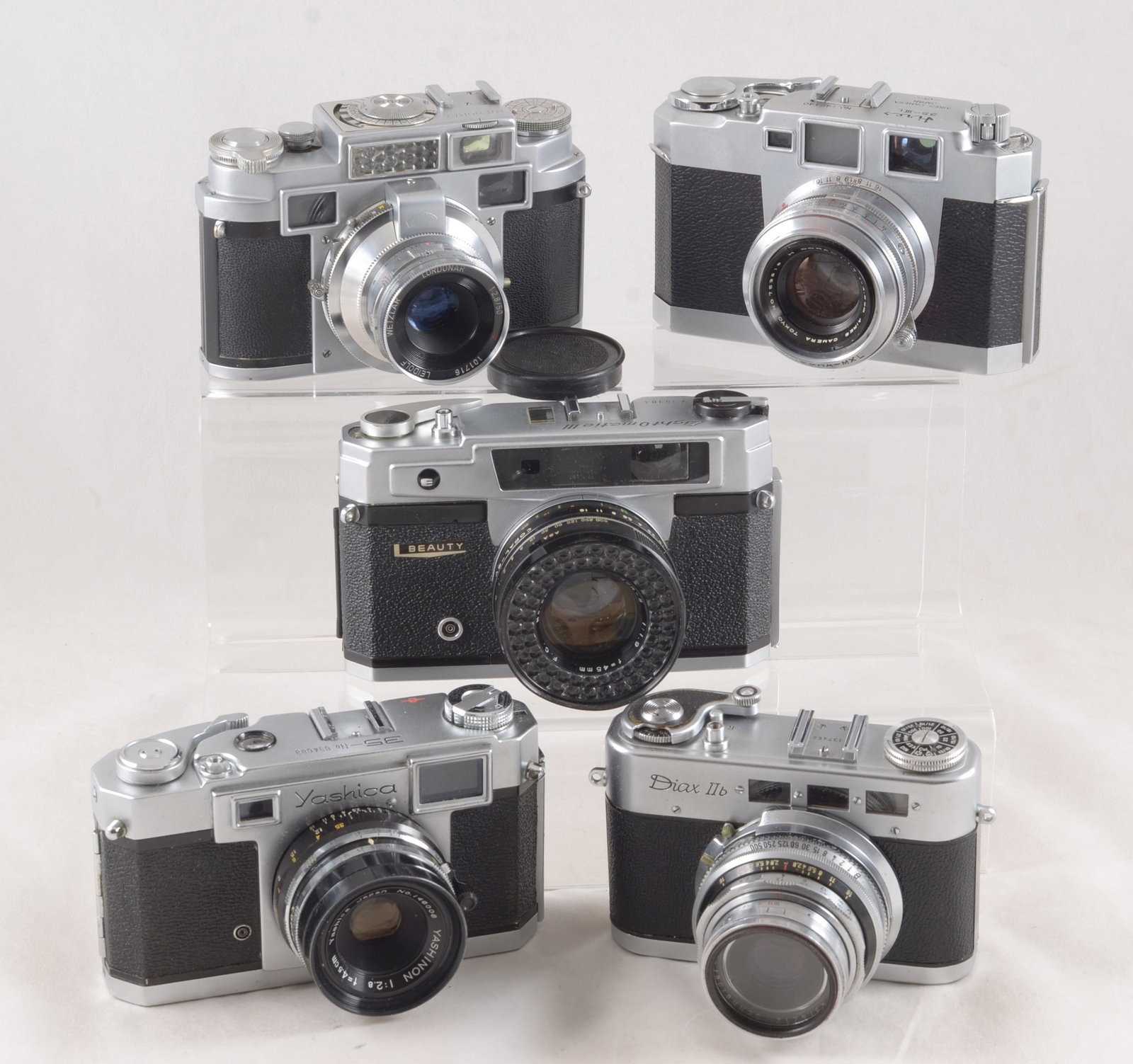 Lordomat & Other 35mm RCF Cameras.: Lordomat & Other 35mm RCF Cameras. Comprising a Lordomat (meter working); Aries 35-IIIL Beauty LightOmatic III; Yashica 35 & a Diax IIb. All with shutters firing (signs of normal use) most with cases.