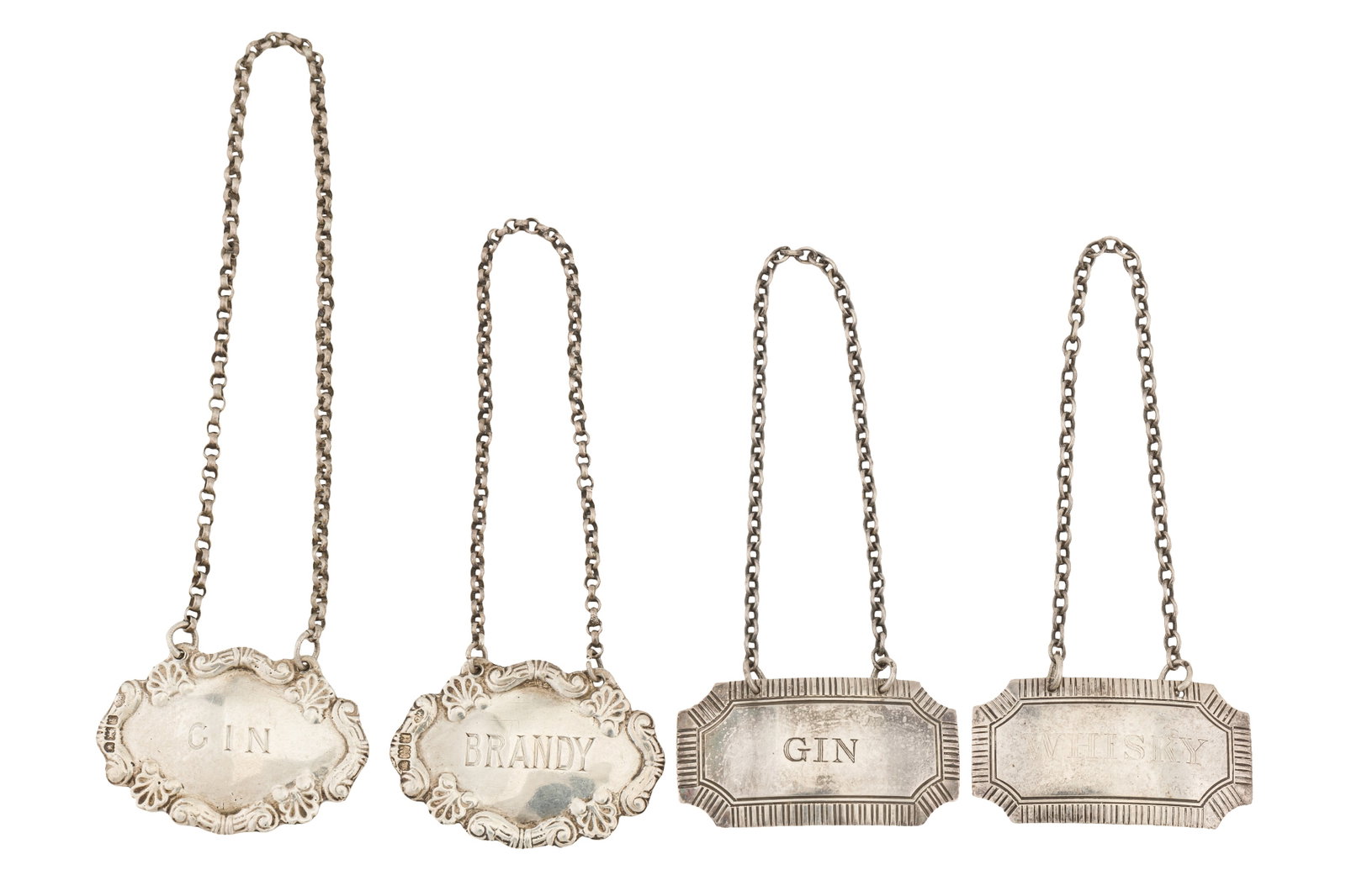 A pair of Edwardian cast sterling silver wine labels, London 1904 by William Comyns: A pair of Edwardian cast sterling silver wine labels, London 1904 by William Comyns Foliate edge, engraved for GIN and BRANDY, another pair Birmingham 1990/93 for GIN and WHISKEY. (4) Weight – 4