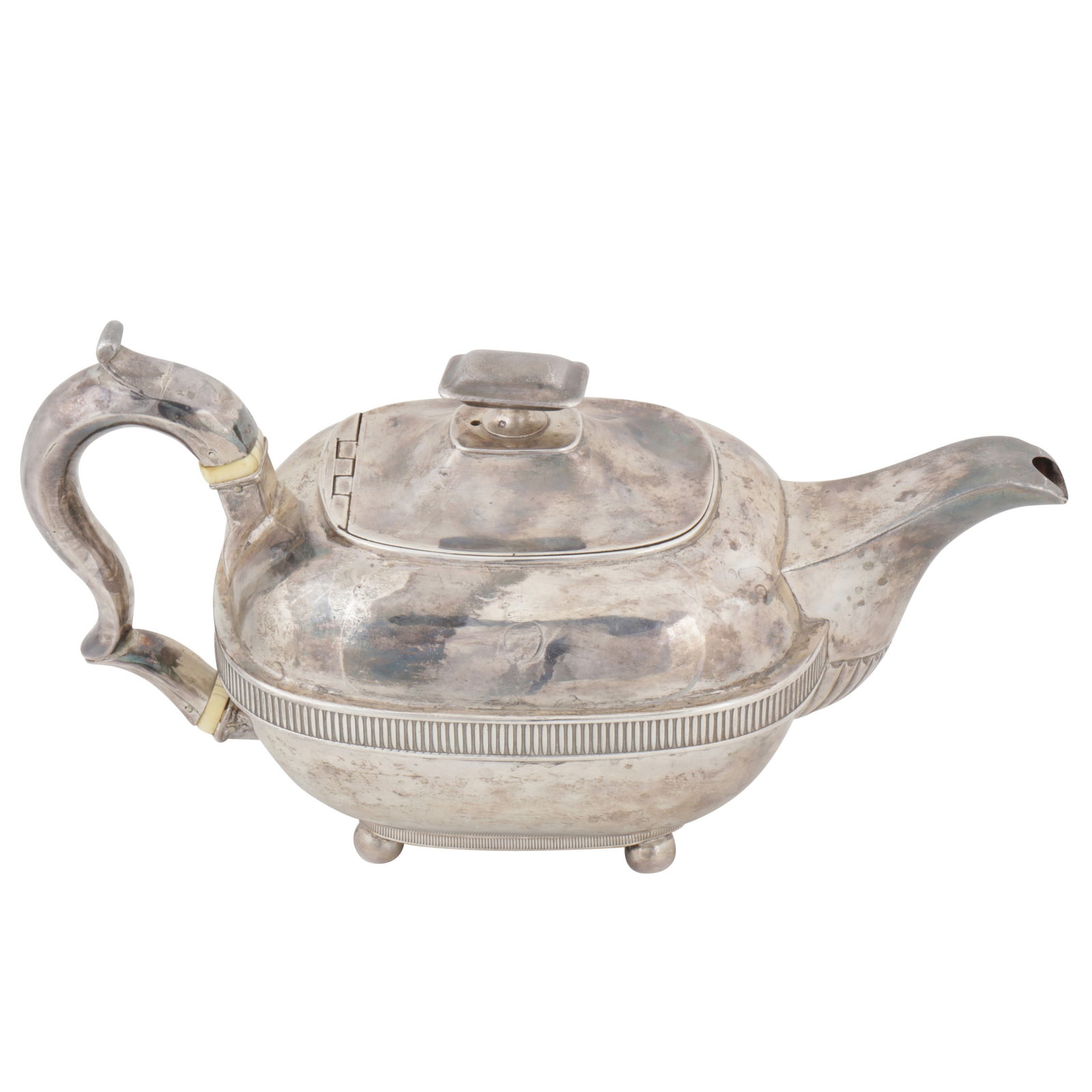 A George III sterling silver teapot, London 1810 by William Bennett: A George III sterling silver teapot, London 1810 by William Bennett A George III sterling silver teapot, London 1810 by William Bennett Of oblong form upon a four ball feet, a fluted central band, th