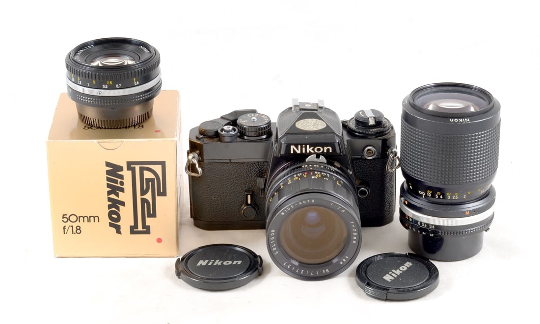 Black Nikon FE Wide & Tele Lens Outfit.: Comprising Nikon FE body 3122309 with signs of normal+ ues. Shutter firing, often not correctly. meter suspect as needle dances wildly. With Nikkor 50mm f1.8 Ais (signs of normal use)in makers box, So