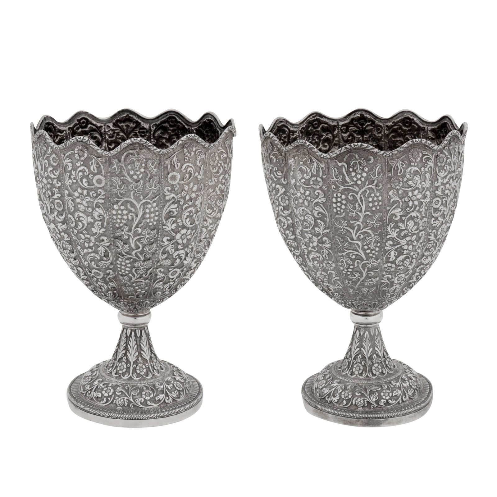 Cutch, probably Bhuj circa 1910 by W&O (unidentified) A pair of early 20th century Anglo – Indian: Raj period. Of rounded circular form with a wavy rim all upon a circular pedestal foot. The main section with alternating bands of chased symmetrical foliate scrolls and rosettes with fruiting vine. T