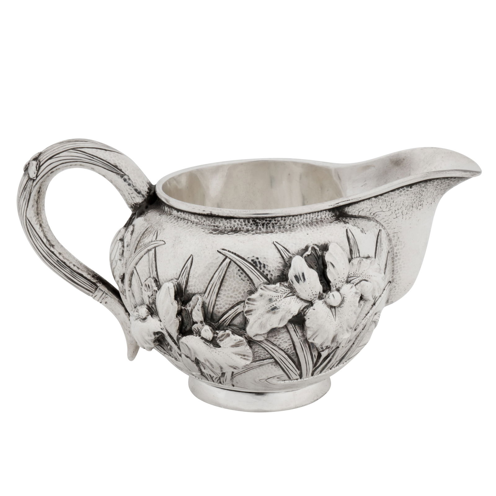 Yokohama circa 1910 An early 20th century Japanese silver milk jug: Meiji period. Of rounded circular form upon a collet foot, C scroll handle. Embossed high relief decoration of iris flowers against a spot hammered ground. Double skinned interior, Marked underneath j