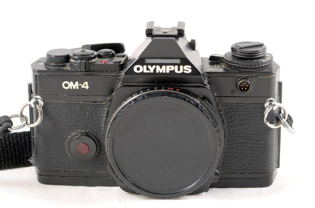 Black Olympus OM-4 Body. Shutter firing and meter responsive but not checked for accuracy.: Black Olympus OM-4 Body. Shutter firing and meter responsive but not checked for accuracy. Signs of normal use with small area of missing paint on film reminder, eyepiece needs cleaning.