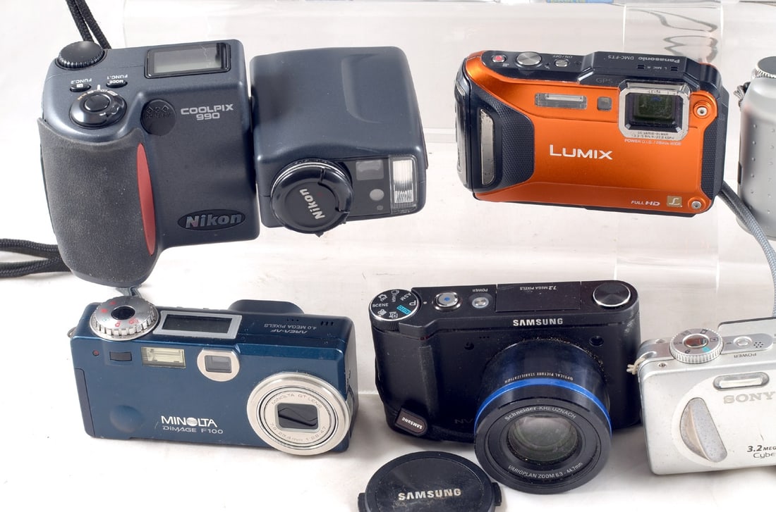 A Group of Digital Cameras. Some with a battery, others for AA or AAA batteries. - 3