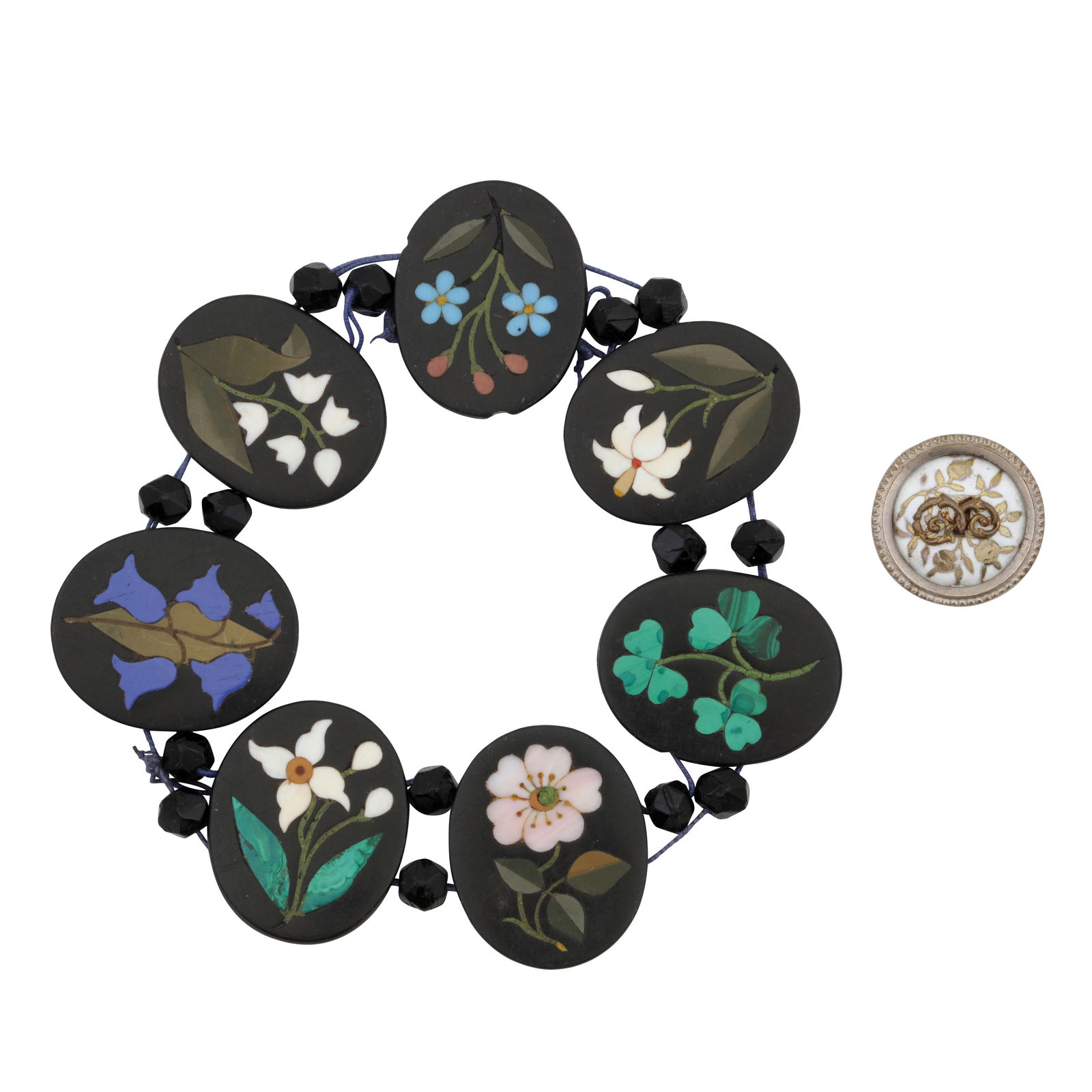 A pietra dura bracelet and a button White metal: A pietra dura bracelet and a button White metal The elasticated pietra dura bracelet set with seven oval panels, decorated with flower motifs, together with a white enamel flower button, unmarked