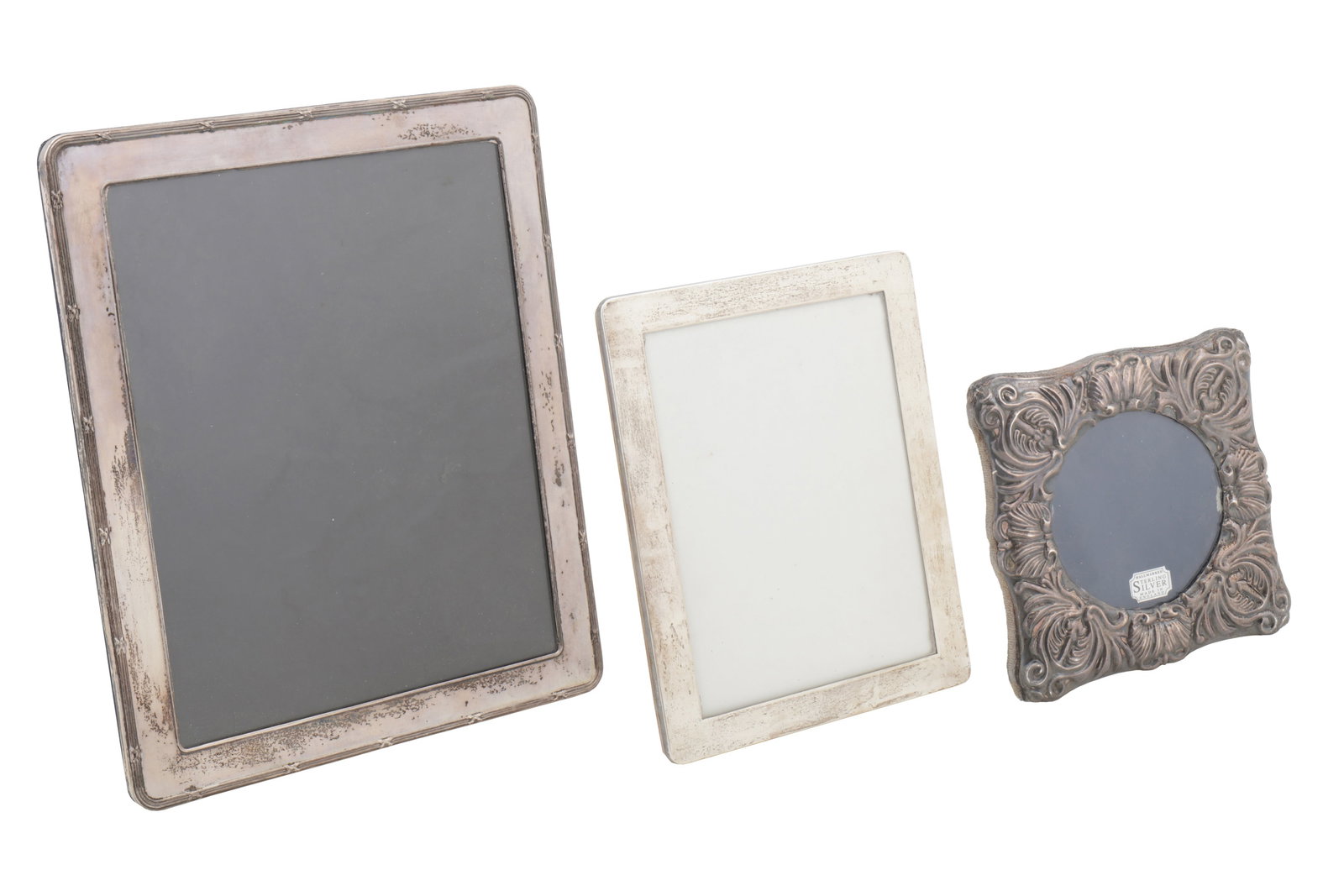 An Elizabeth II sterling silver photograph frame, London 1994: An Elizabeth II sterling silver photograph frame, London 1994 An Elizabeth II sterling silver photograph frame, London 1994 Reed and ribbon edge, 25.1 cm x 30.2 cm . Together with another London 1989