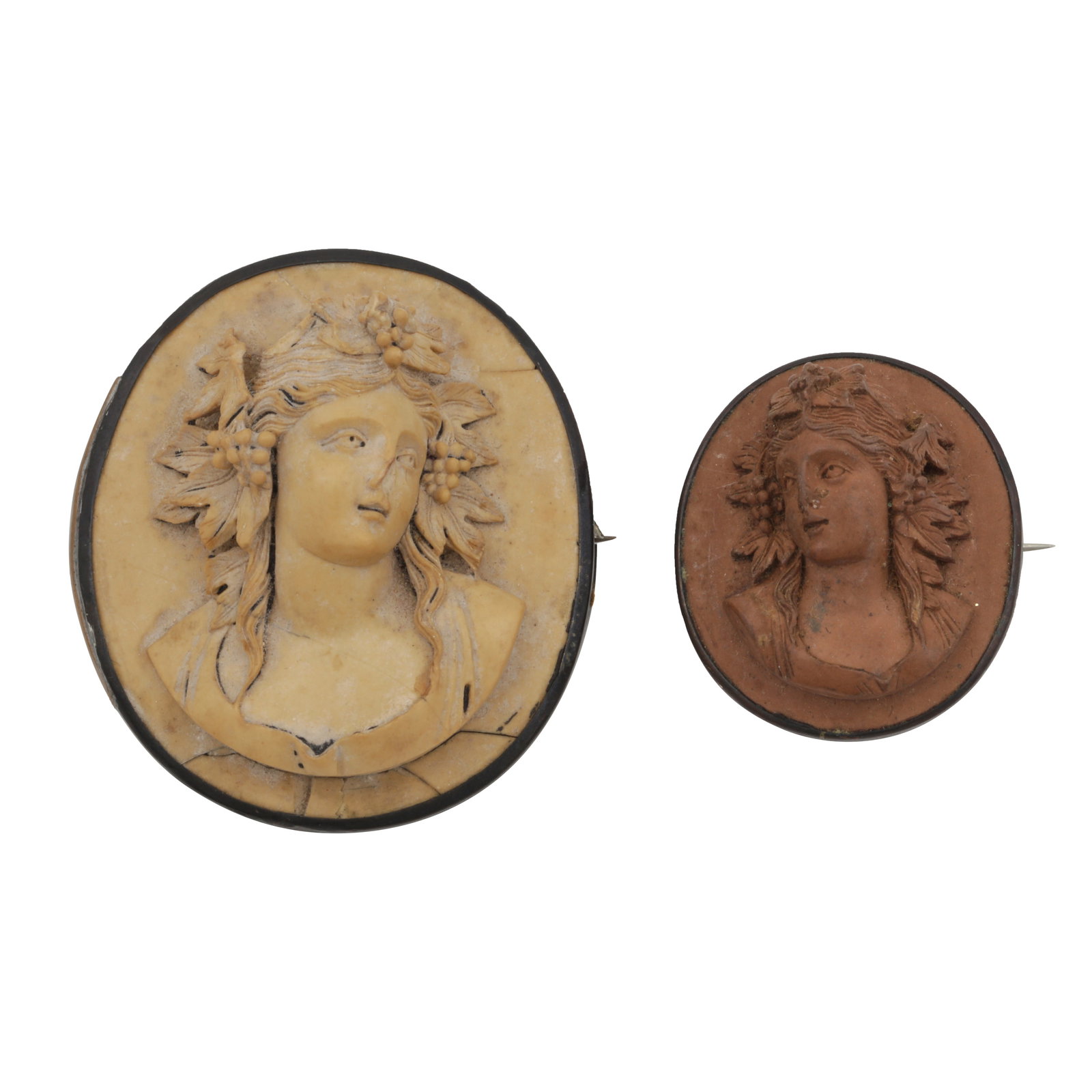 Two lava cameo brooches Black metal: Two lava cameo brooches Black metal Of oval form, within balck metal frames, unmarked, lengths: 4.4cm & 5.1cm (2)