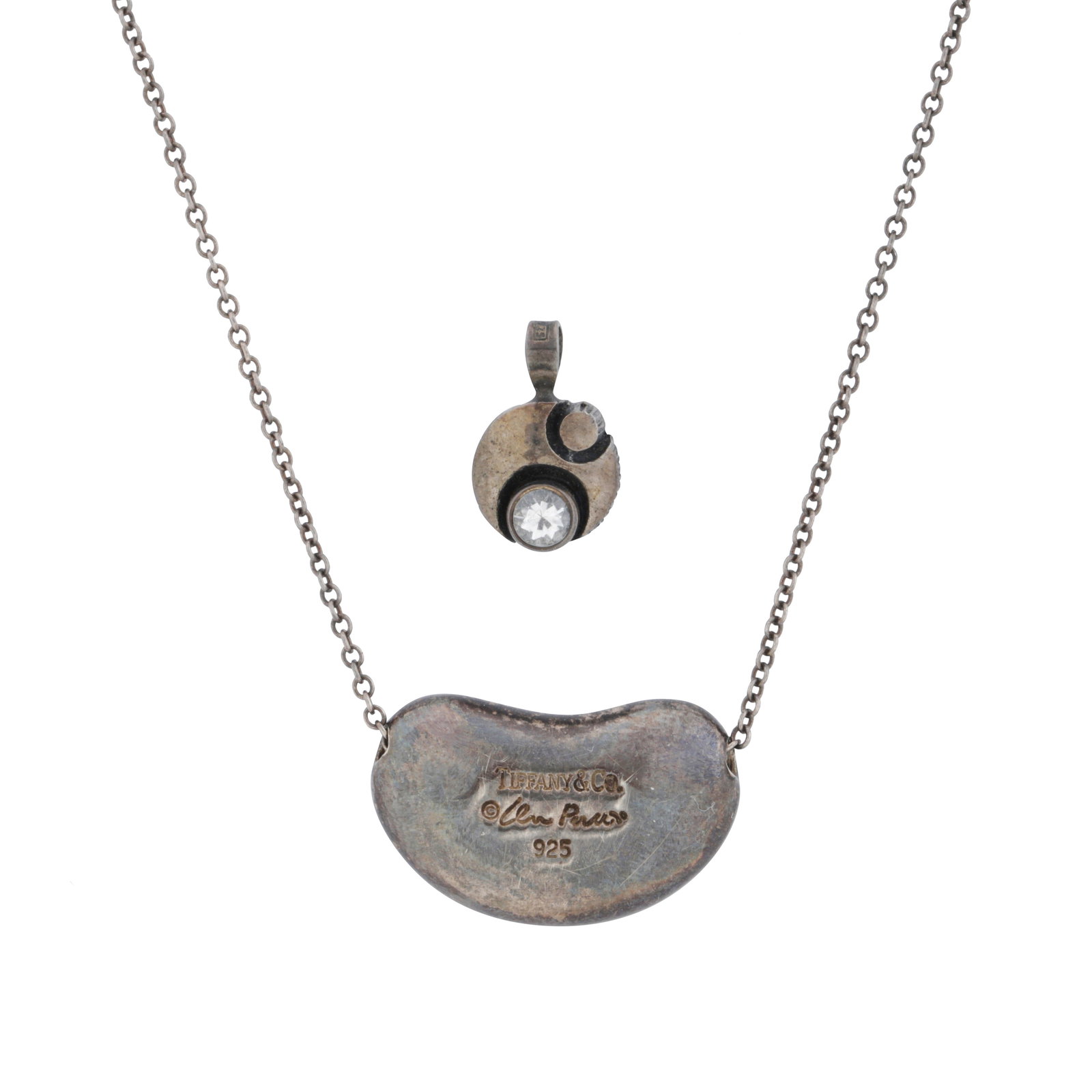 Tiffany & Co. by Elsa Peretti | A 'Bean' necklace White metal: Tiffany & Co. by Elsa Peretti | A 'Bean' necklace White metal The undetachable bean pendant, set on a cable-link chain necklace, to a bolt-ring clasp, mounted in white metal, signed, length 60.0cm,
