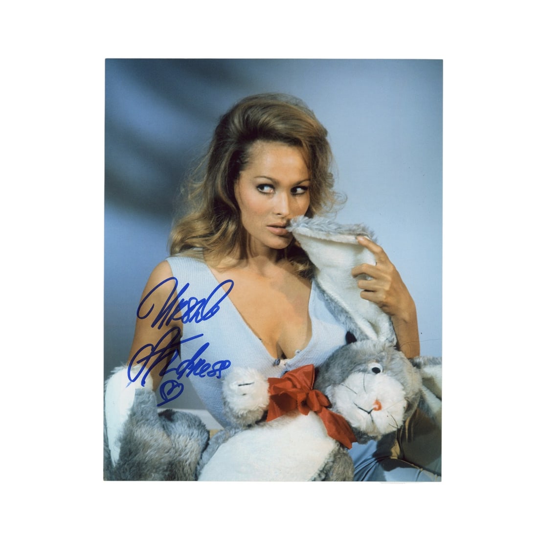Andress (Ursula) Signed photograph: Andress (Ursula) Signed photograph Glossy colour photograph of Ursula Andress in a seductive pose, signed by the actress in blue ink. Dimensions:10 x 8"/ 25.5 x 20.5cm