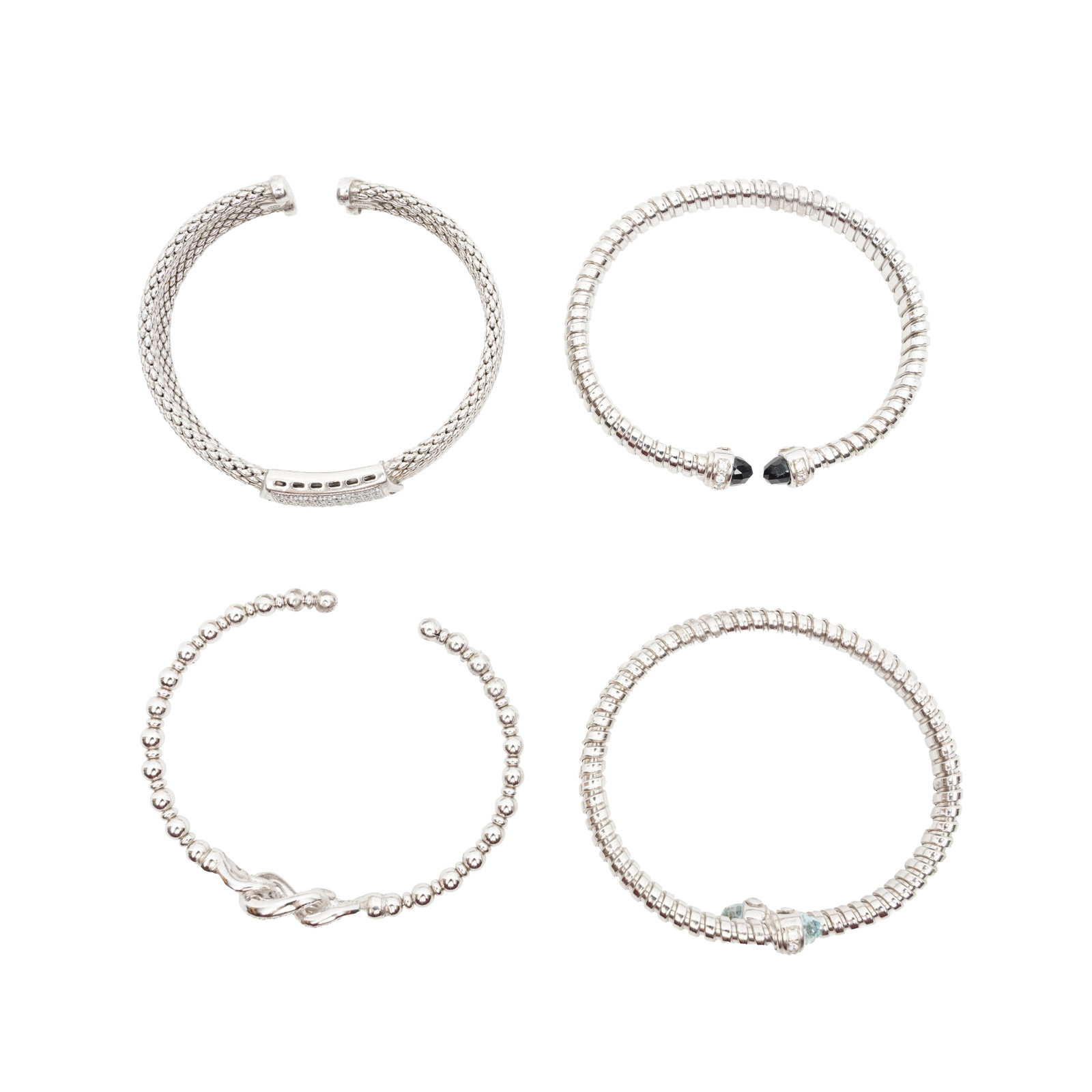 Four gem-set bangles White metal: Four gem-set bangles White metal All mounted in white metal; stamped 935; various sizes (4)