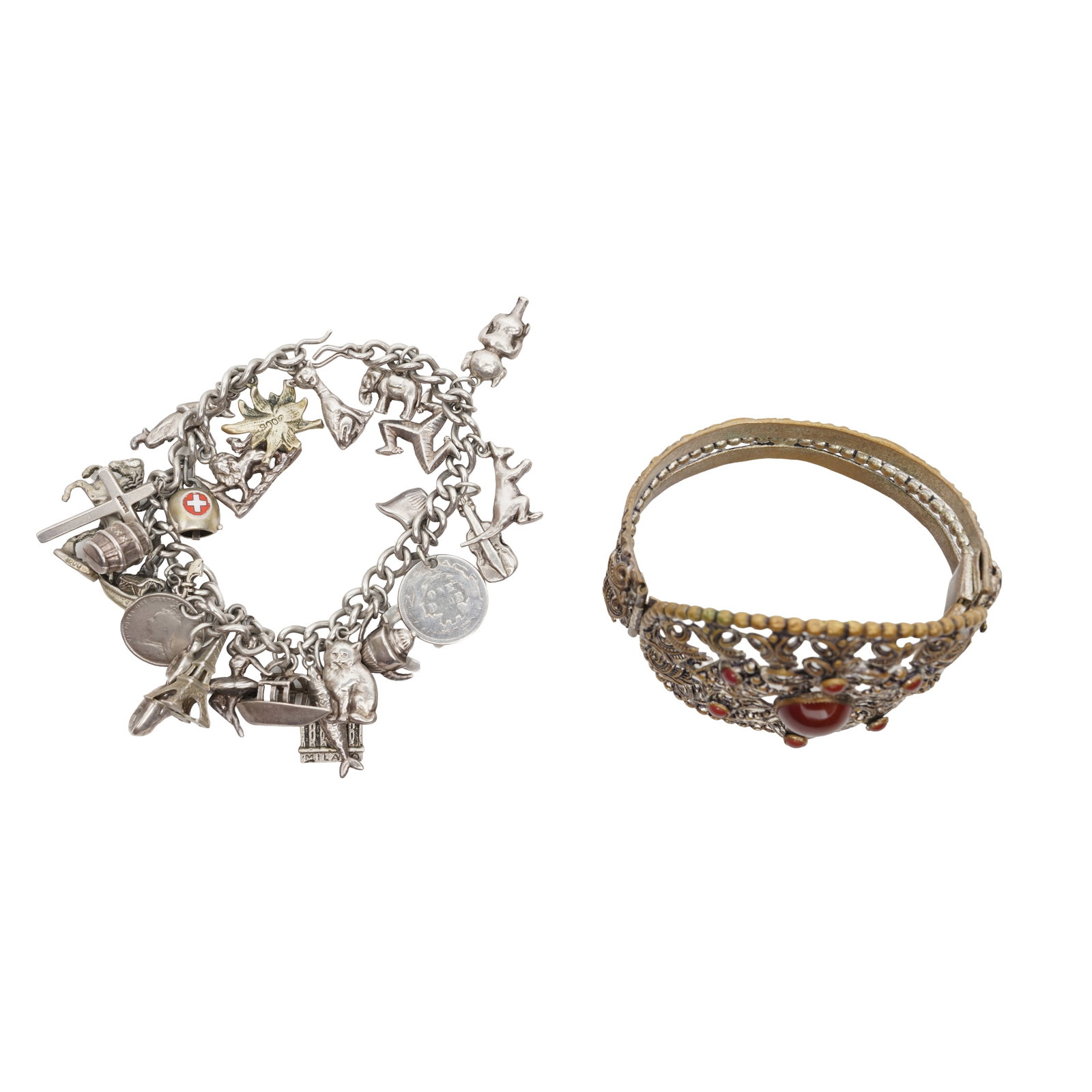 A silver charm bracelet and a carnelian bangle White metal: A silver charm bracelet and a carnelian bangle White metal The curb-link chain bracelet suspending twenty-one charms, featuring some animals, some monuments, two boats, Two coins, a cross, a
