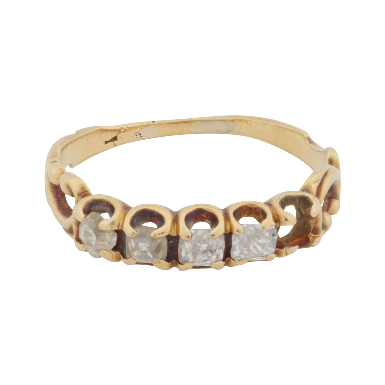 A four stone diamond ring Yellow metal: A four stone diamond ring Yellow metal Of scroll design, set with cushion-shaped old-cut diamonds (one stone deficient), to textured shoulders, diamonds approx. 0.30 carat total, unmarked and