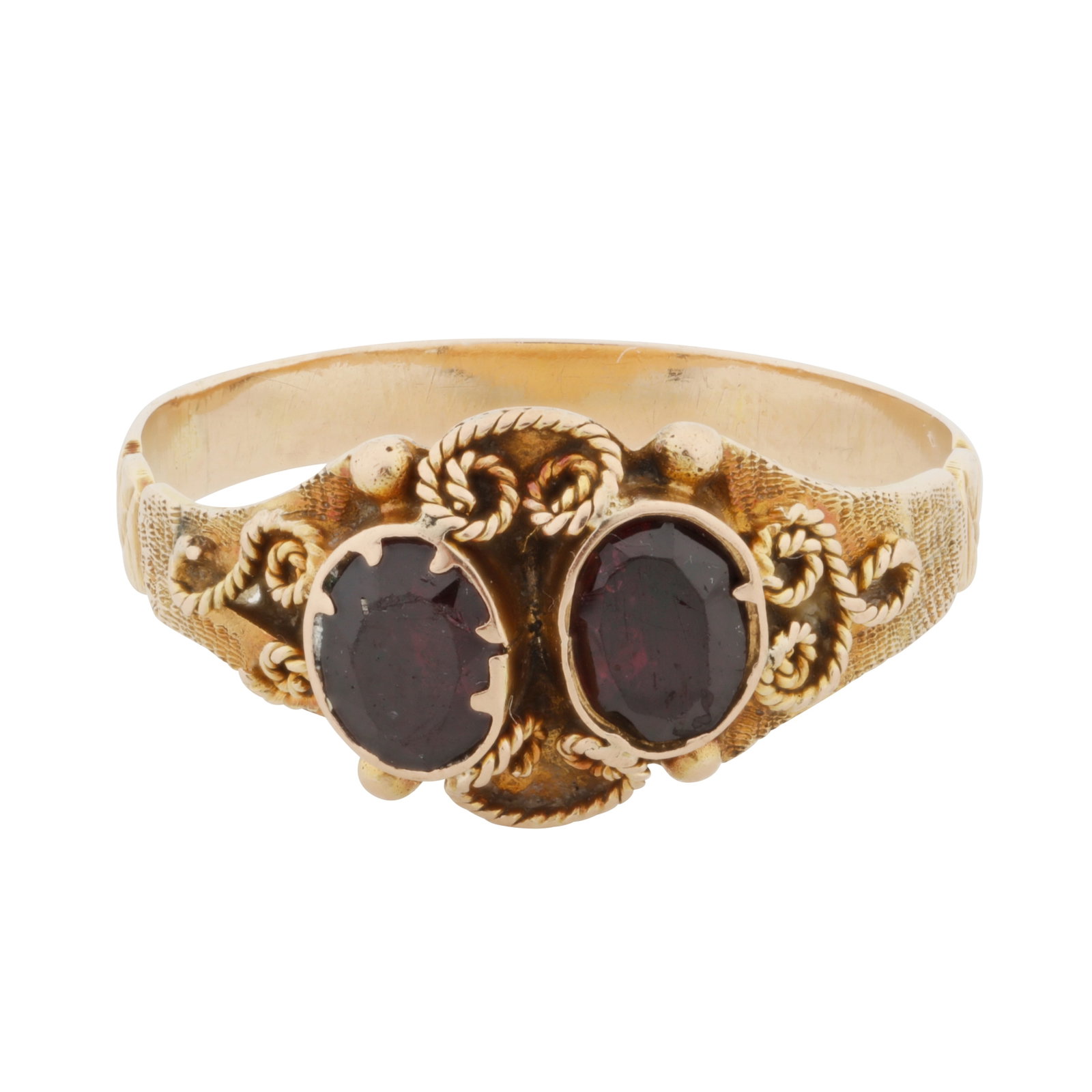A garnet two stone ring Yellow metal: A garnet two stone ring Yellow metal Set with circular-cut garnets, to rope-twist decorations on a textured background, unmarked, ring size O The item has been XRF tested and found to be the shank