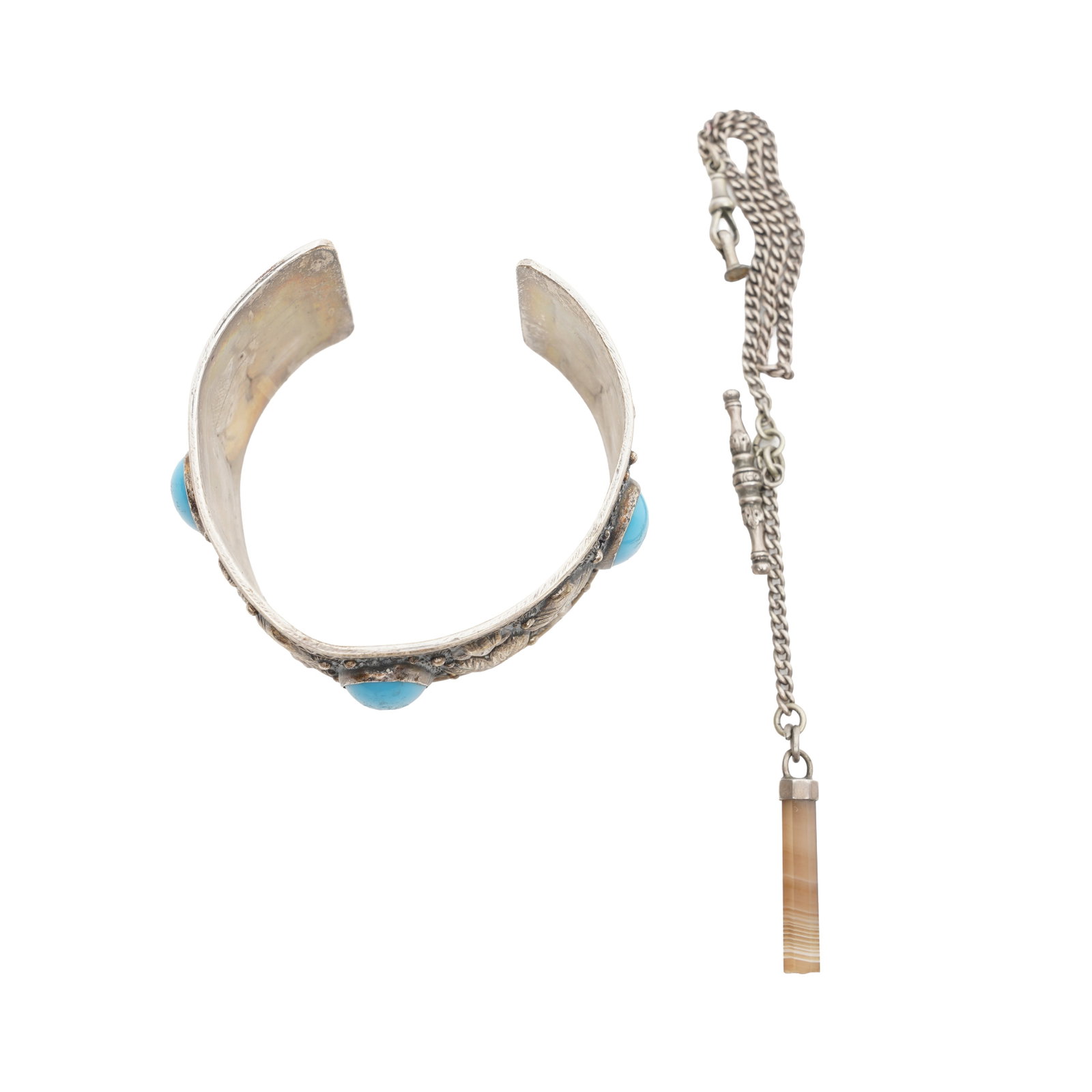 A bangle and a watch chain White metal: A bangle and a watch chain White metal A turquoise bangle set at its front with three turquoise cabochons; and a watch chain suspending an octagonal agate pendant; both set in white metal; unmarked;