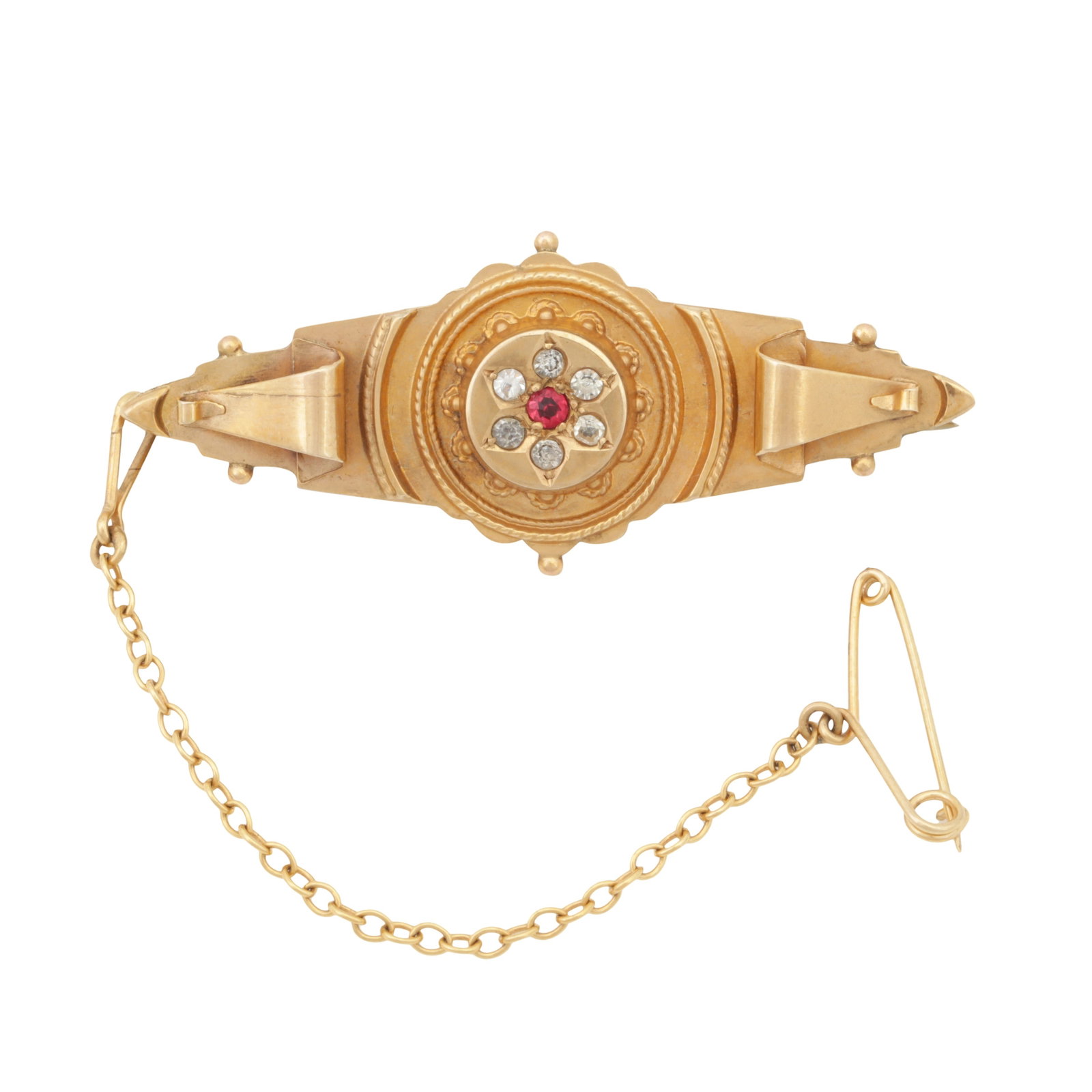 An Edwardian ruby and diamond brooch Yellow metal: An Edwardian ruby and diamond brooch Yellow metal Centrally set with a circular-cut ruby, surrounded by old-cut diamonds, to a textured mount and a glass compartment on its back, pin and safety