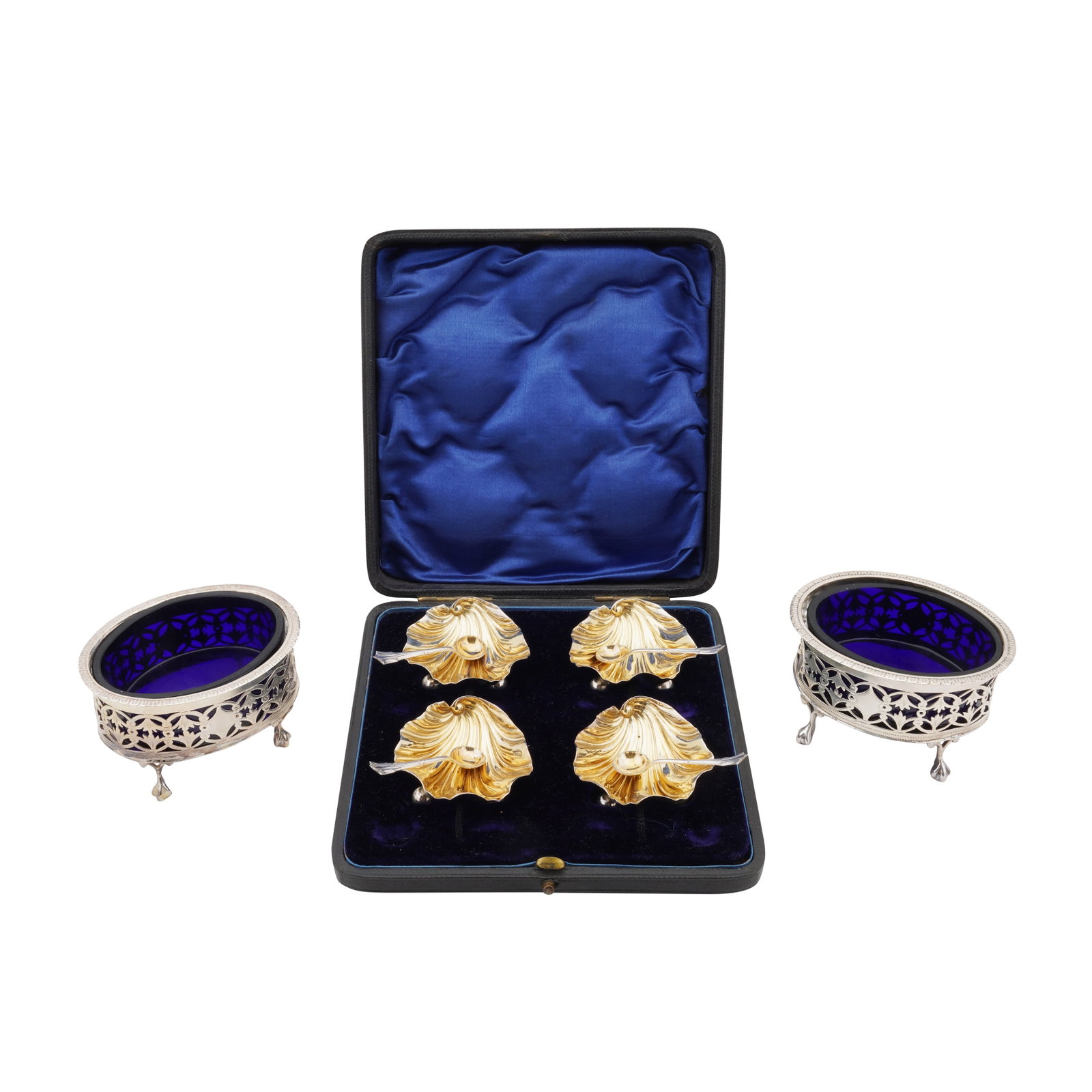 Chester 1904 by Lewis Hart A pair of Edwardian sterling silver salts: Chester 1904 by Lewis Hart A pair of Edwardian sterling silver salts Oval pierced form. Blue glass liners. Together with a cased set of four shell salt with spoons. Weight – 179 grams / 5.75 ozt