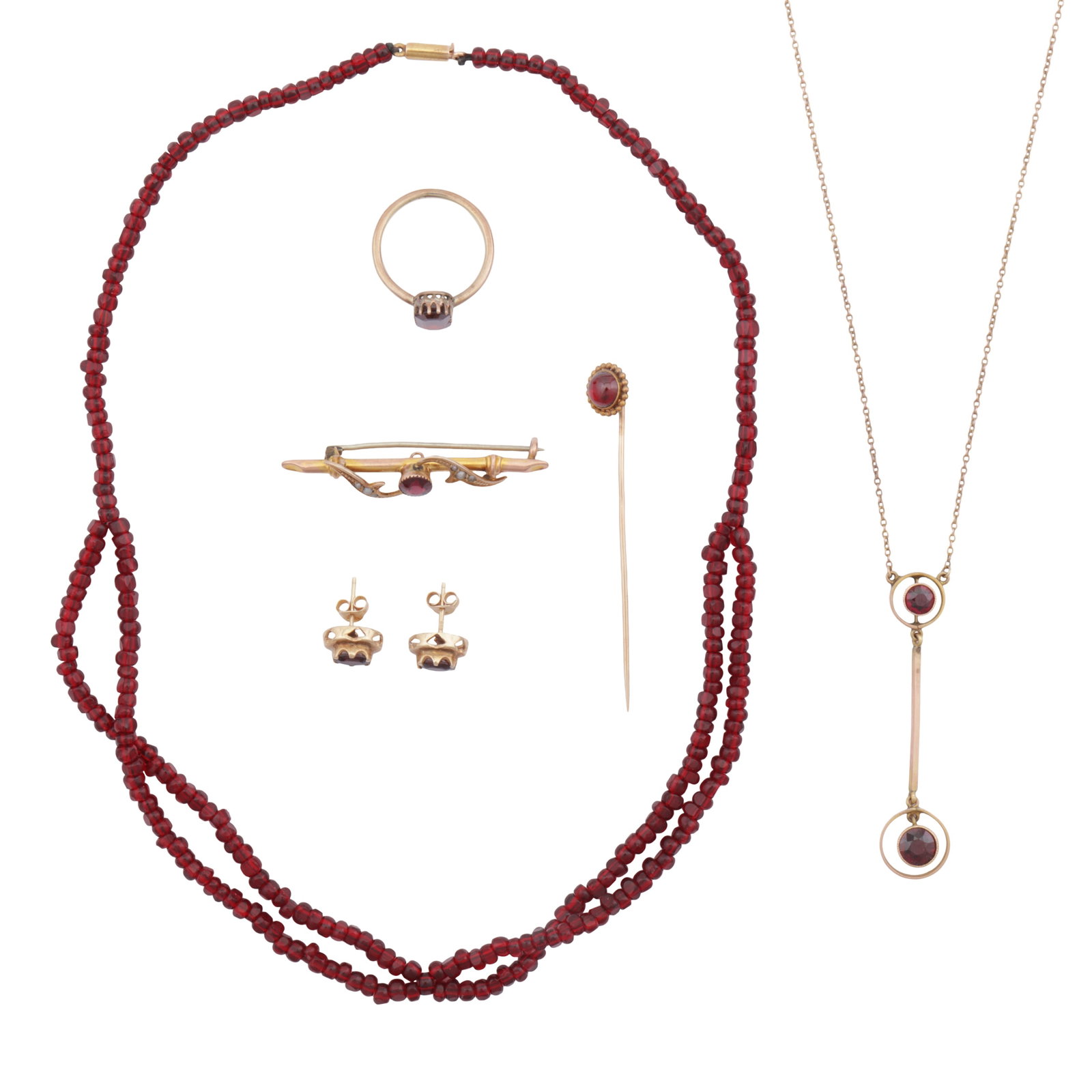 A group of garnet jewellery Yellow metal: A group of garnet jewellery Yellow metal Including a bead necklace, a circular-cut pendant necklace, a cabochon stickpin, a circular-cut brooch, oval-cut earrings; an octagonal step-cut ring; all set 