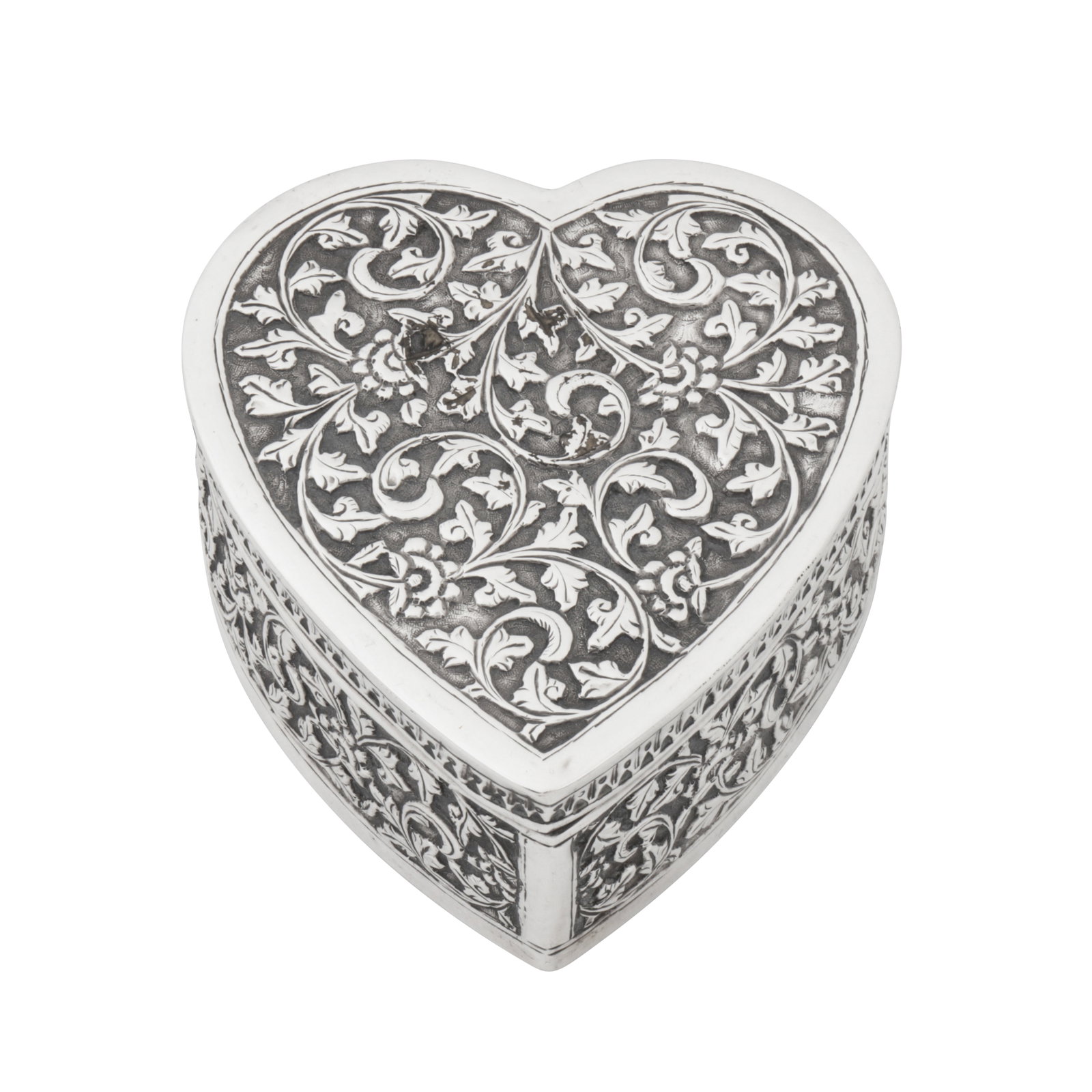 Bombay circa 1920 An early 20th century Anglo-Indian unmarked silver box: Bombay circa 1920 An early 20th century Anglo-Indian unmarked silver box Raj period. Of heart shaped form with a pull off lid. All over decoration in the Cutch style of foliate scrolls and rosettes. L