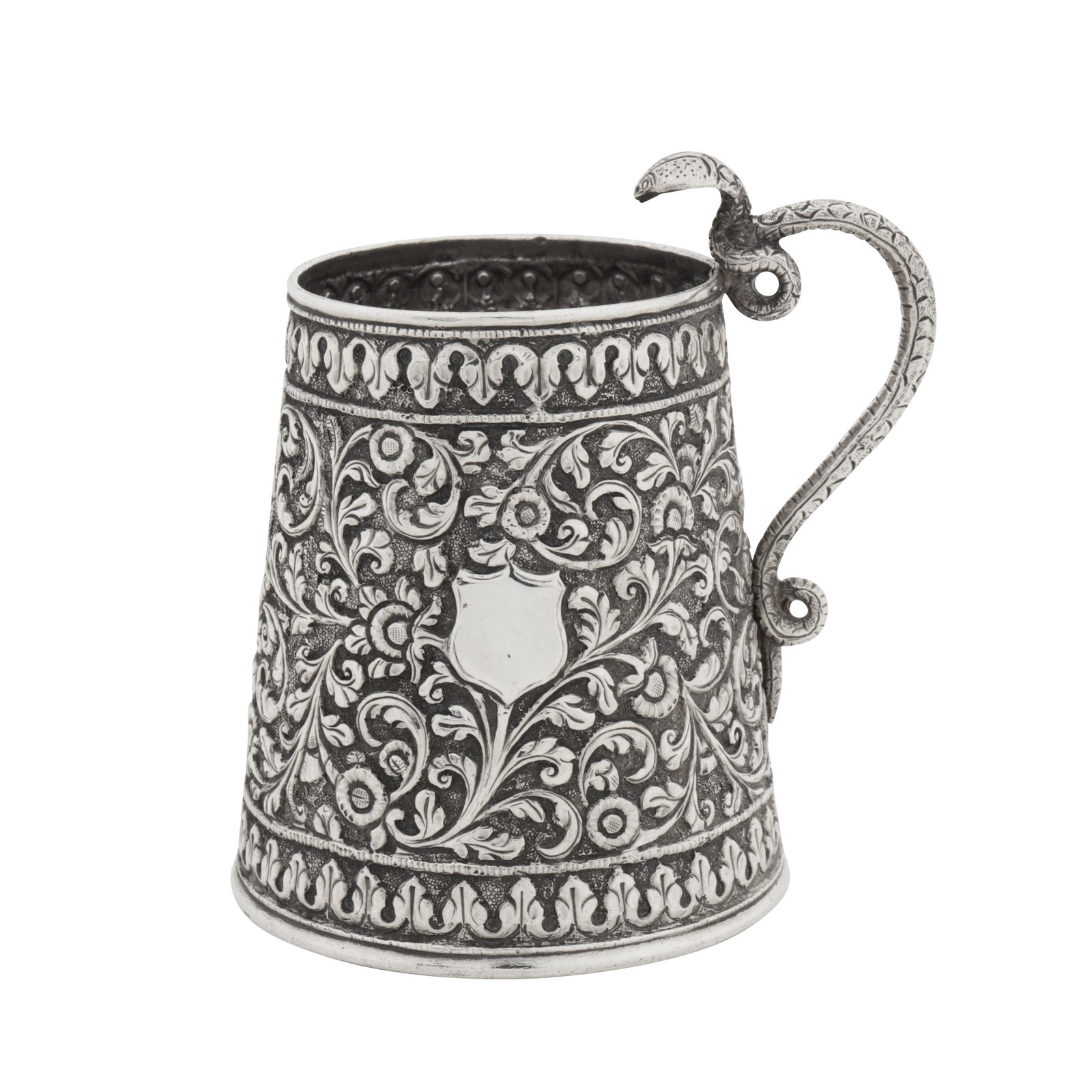 Cutch circa 1890 A late 19th century Anglo – Indian unmarked silver small mug: Cutch circa 1890 A late 19th century Anglo – Indian unmarked silver small mug Raj period. Of tapering cylindrical form with deep chased decoration of foliate scrolls and rosettes, the side with a va