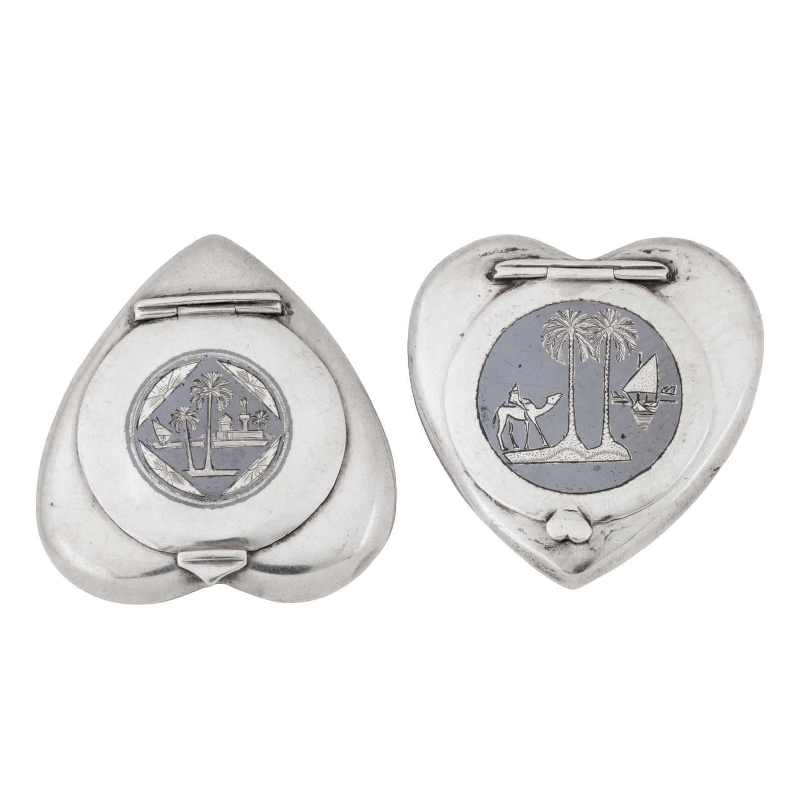 Basra circa 1950 Two mid 20th century Iraqi silver and niello compacts: Basra circa 1950 Two mid 20th century Iraqi silver and niello compacts Each of heart shape with hinged lids. One, with niello decoration of the Tomb of Ezra within a lozenge with date palm trees. The 