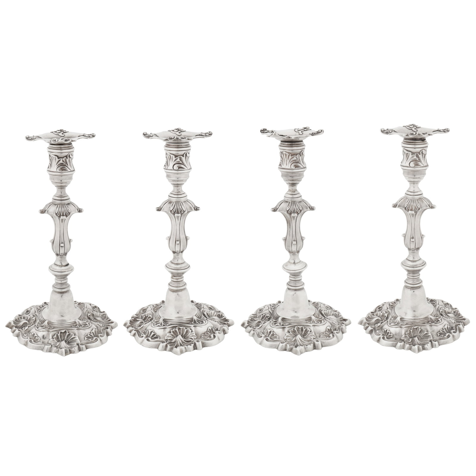 London 1824 by Paul Storr (1771 - 1844, reg. 12th Jan 1793) A set of four George IV sterling silver: London 1824 by Paul Storr (1771 - 1844, reg. 12th Jan 1793) A set of four George IV sterling silver candlesticks Each of shaped circular form with asymmetrical husk shells rising to a knopped stem wit