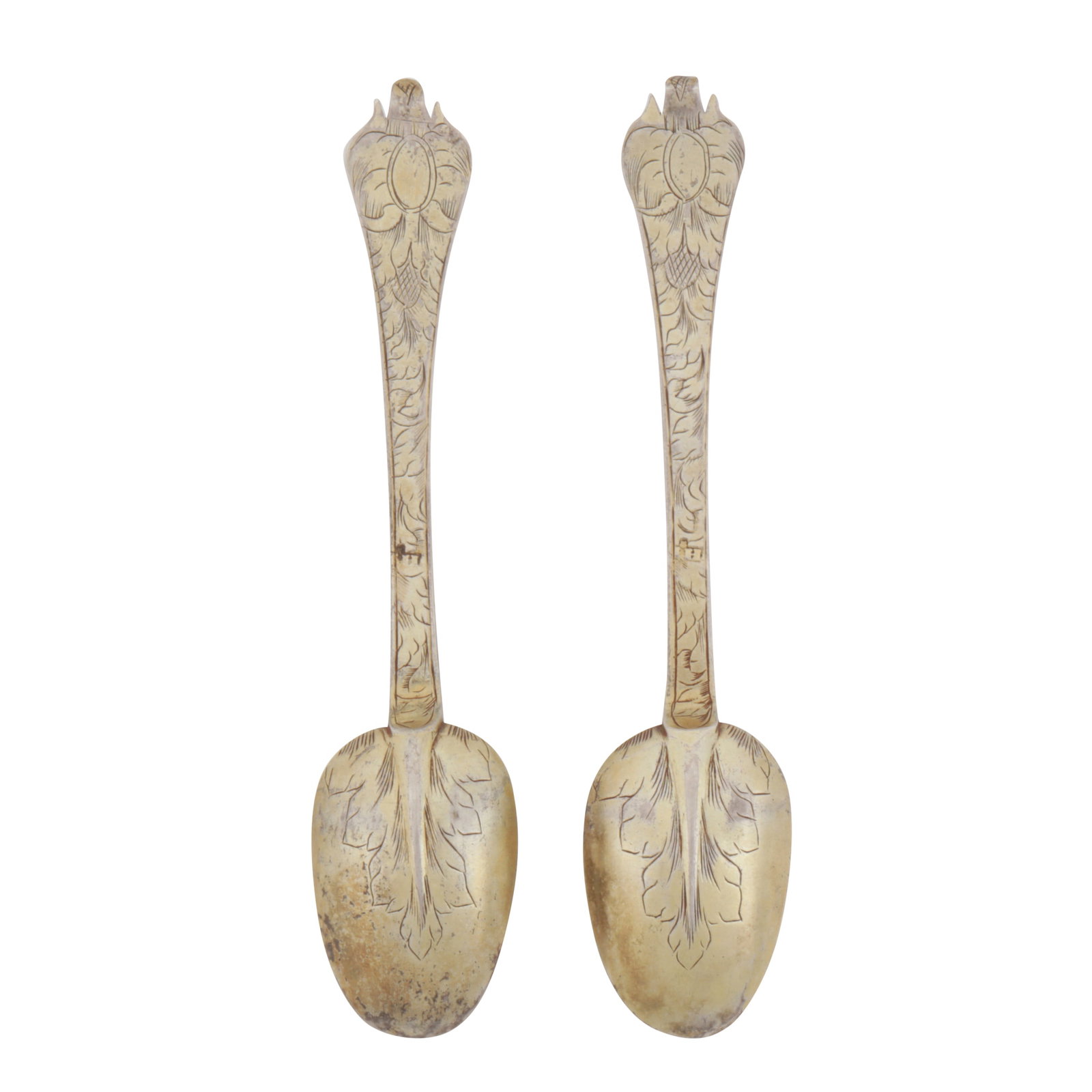 London circa 1690 by IH with a mullet above A pair of William and Mary silver gilt teaspoons: London circa 1690 by IH with a mullet above A pair of William and Mary silver gilt teaspoons Trifid pattern, rat tail heel, engraved with foliate decoration. Each marked with maker’s mark. (2) Lengt