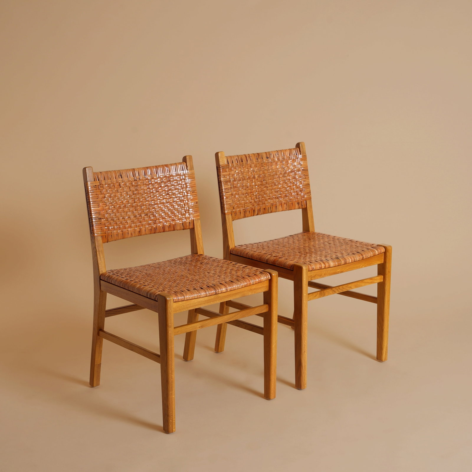 Williams Sonoma, USA Pair of Dining Chairs: 2020s Ratan, walnut Plaque to underside 71cm high x 46cm wide x 52cm deep Provenance: From a Distinguished Private International Collection