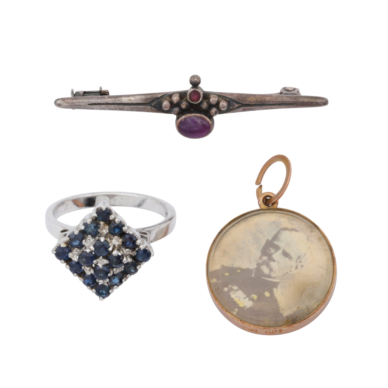 A group of three items White and yellow metal: A group of three items White and yellow metal Including a circular cut sapphire ring, to a white mount stamped '925', ring size L; a photo pendant, mounted in a yellow frame, stamped '9ct', broken