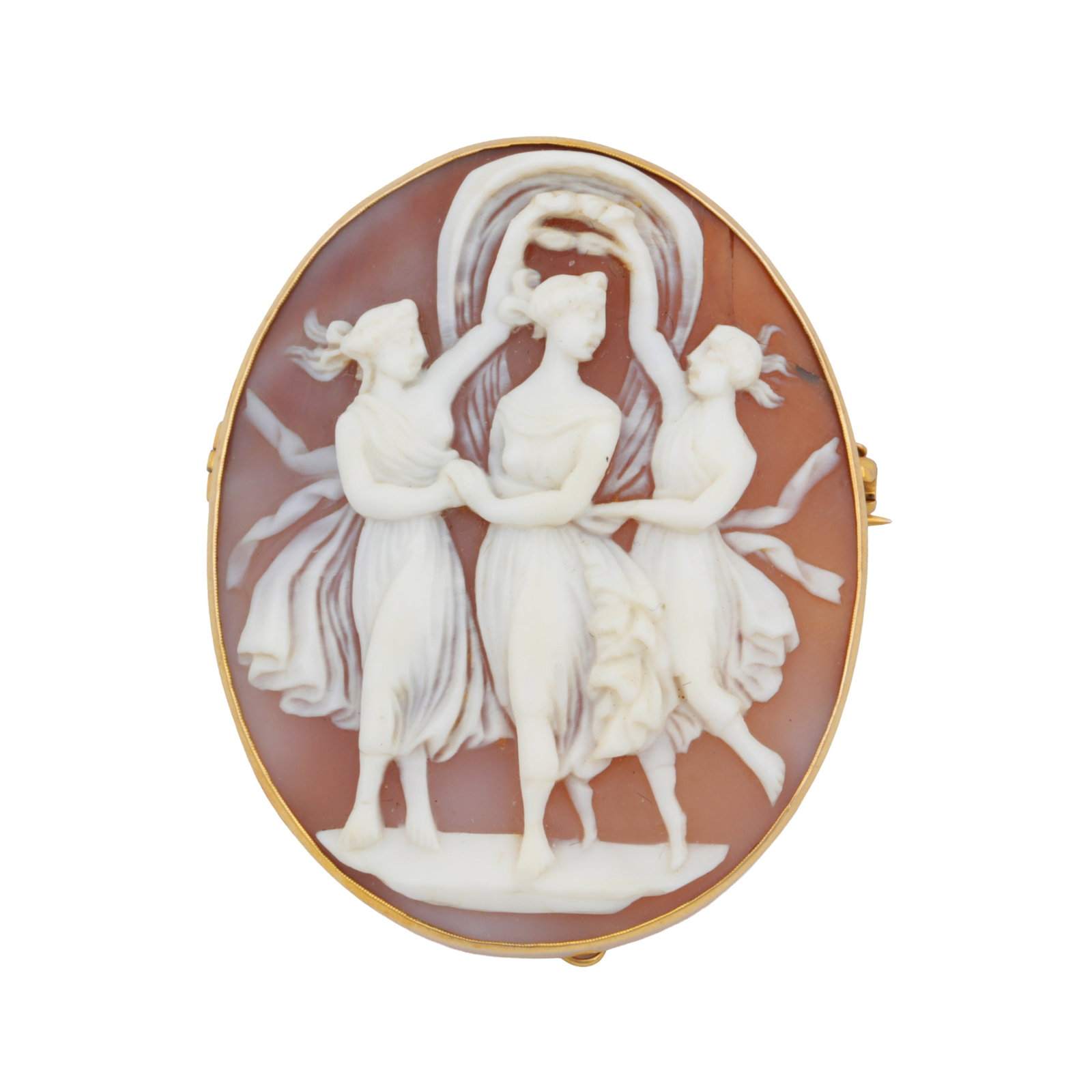 A shell cameo brooch Yellow metal: A shell cameo brooch Yellow metal Carved to depict three female figures set within an oval yellow metal frame stamped 9CT, with brooch fitting and safety chain, length 5.0cm
