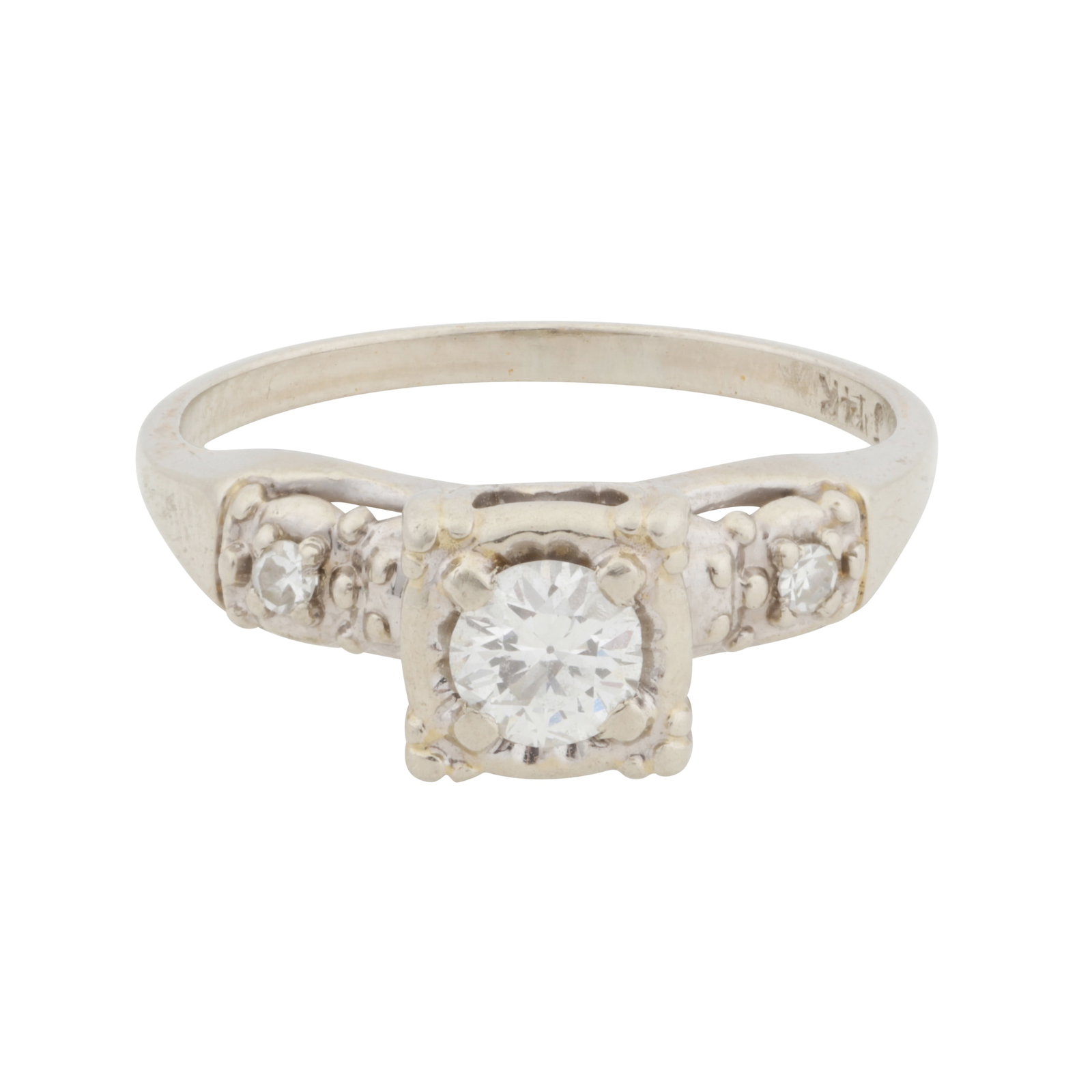 A diamond three stone ring White metal: A diamond three stone ring White metal The illusion-set brilliant-cut diamond centre, in a raised mount, to single-cut diamond-set shoulders, diamonds approx. 0.35 total carat, maker's mark, stamped 1