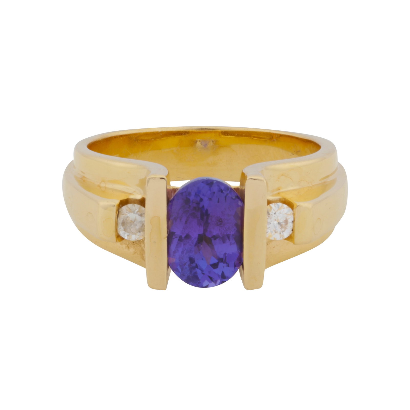 A tanzanite and diamond three-stone ring Yellow metal: A tanzanite and diamond three-stone ring Yellow metal Bar-set with an oval-cut tanzanite, flanked by brilliant-cut diamonds, to a triple tapered band, maker's mark, stamped 18K, ring size M