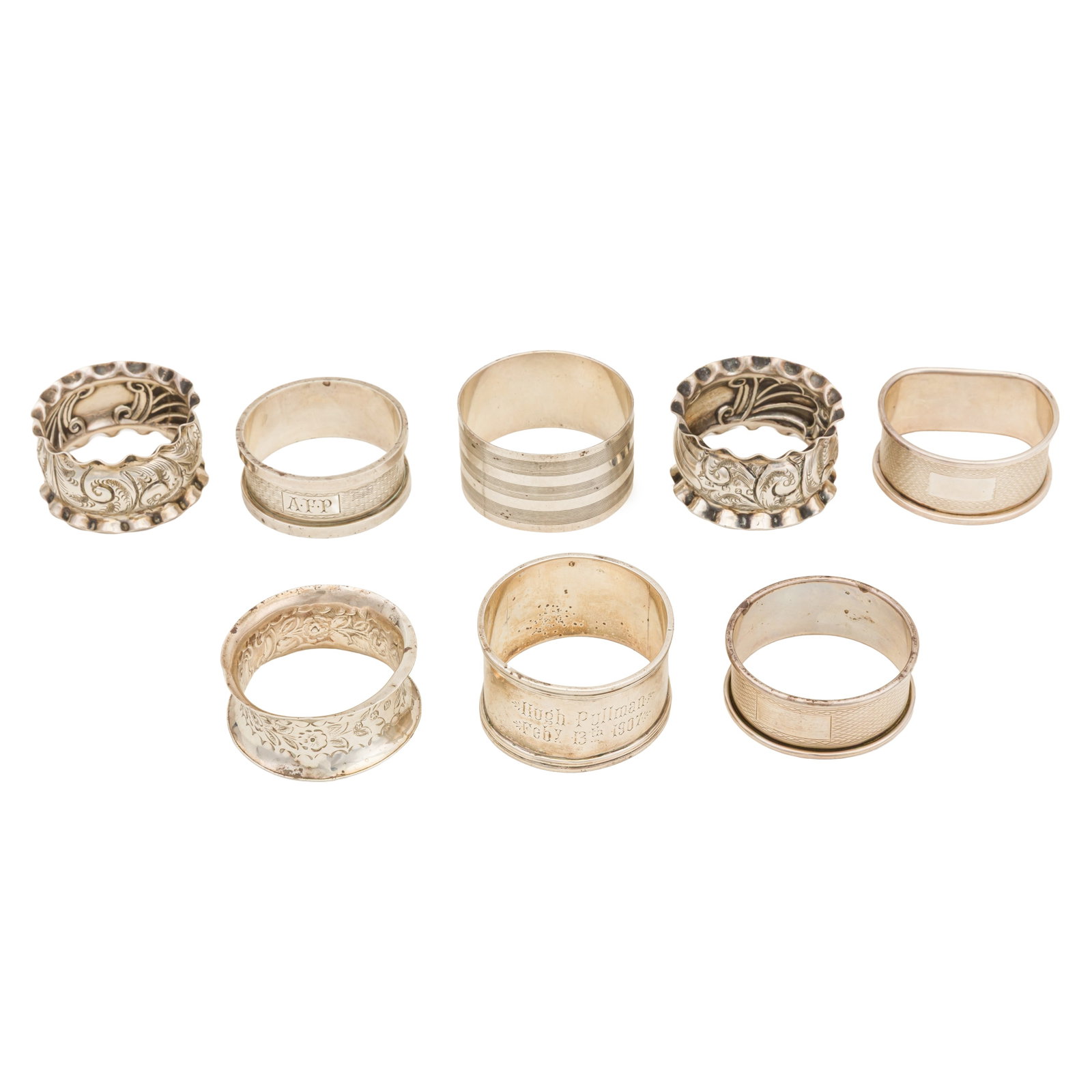 A mixed group of sterling silver napkin rings: A mixed group of sterling silver napkin rings Including a pair with embossed decoration of scrolls and flared edges, Birmingham 1899 by Henry Pope. (8) Diameter - 4.4 cm / 1.73 inches Weight - 147