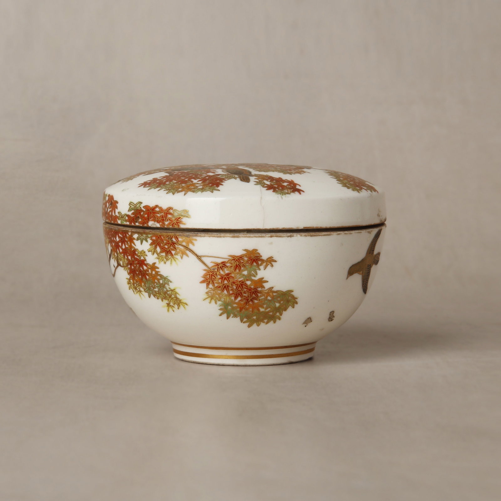 A small Japanese Satsuma 'birds and maple' box and cover by Kinkozan, Meiji period, 19th century: The finely potted box and cover of flattened form, decorated to the exterior with birds and flowers, the base bearing a mark of Satsuma Kinkozan zo Size:(7.5cm diameter) Qty: (2)