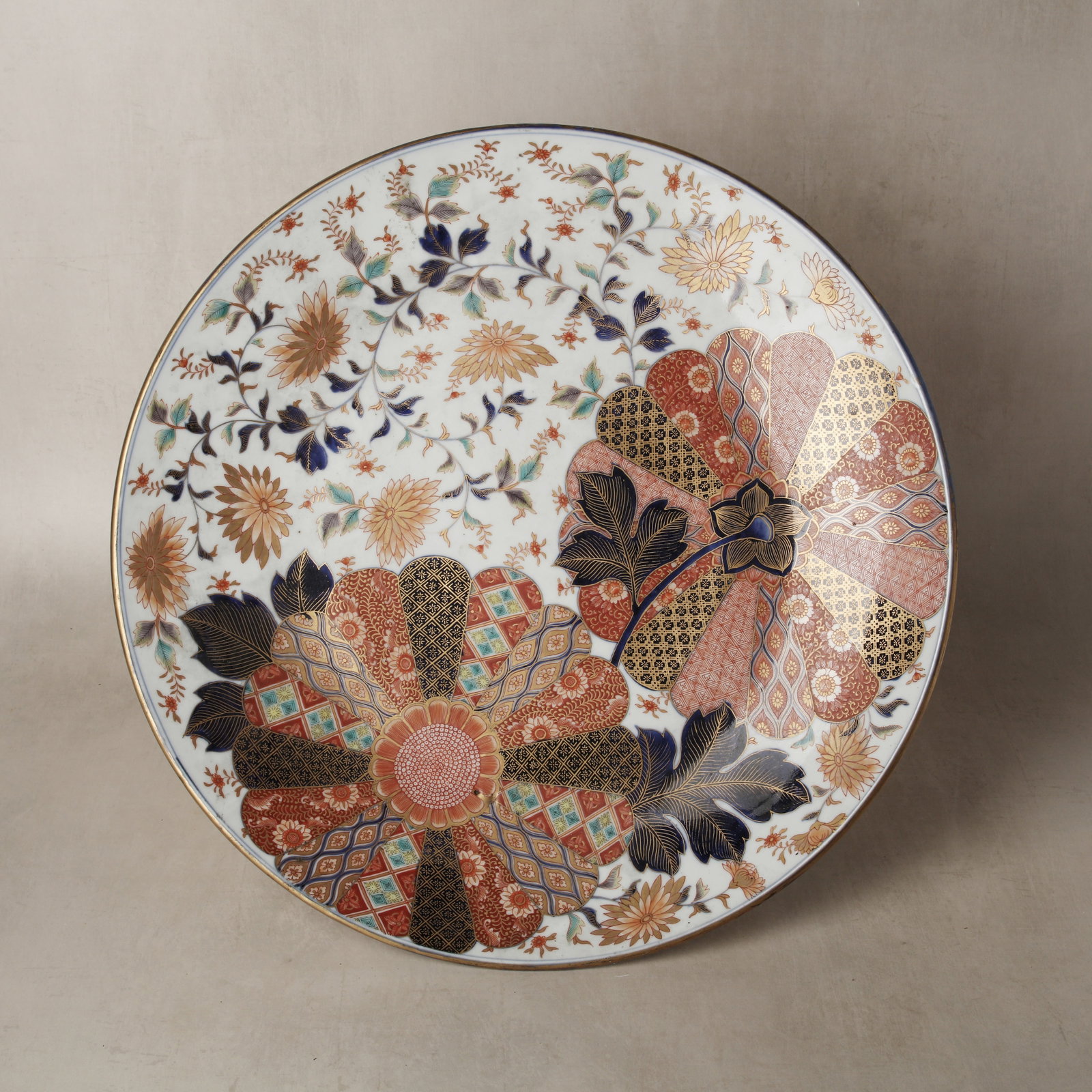 A large Japanese Arita Imari 'floral medallion' charger, Meiji period, 19th century Fukagawa sei: The finely potted charger dish of large proportions, decorated with large floral medallions in the form of stylised chrysanthemum flowers further adorned within with geometric patterns, further decora