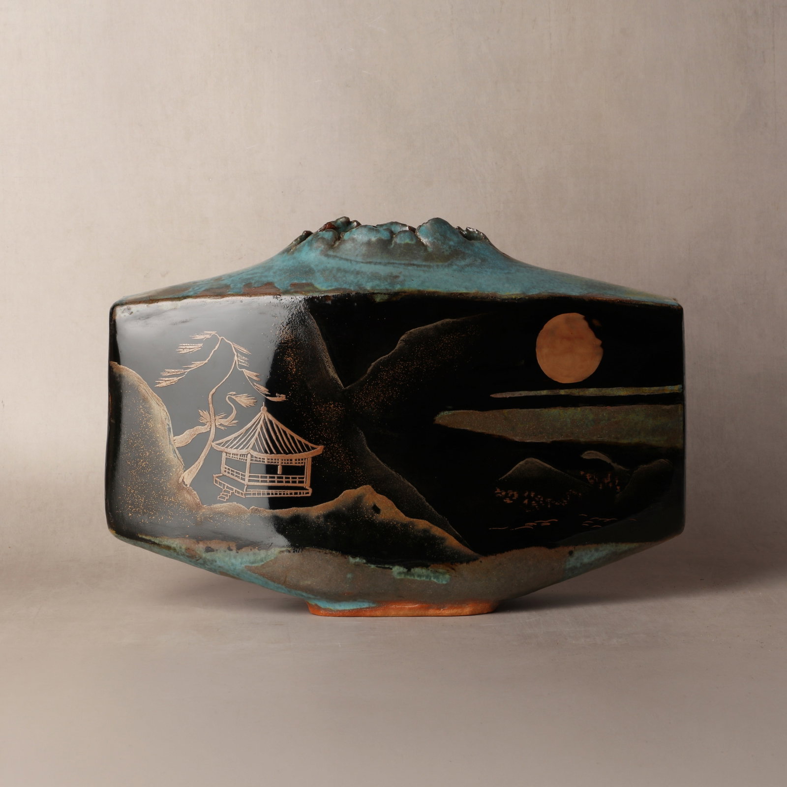 Kato Kozan (Japanese) and Ikenoura Taiki III (Japanese, b. 1944): The finely potted vase of pillow-shape and flattened form rising to a dramatic opening, the top and bottom sections decorated with green against the black body, further decorated by Ikenoura Taiki in 