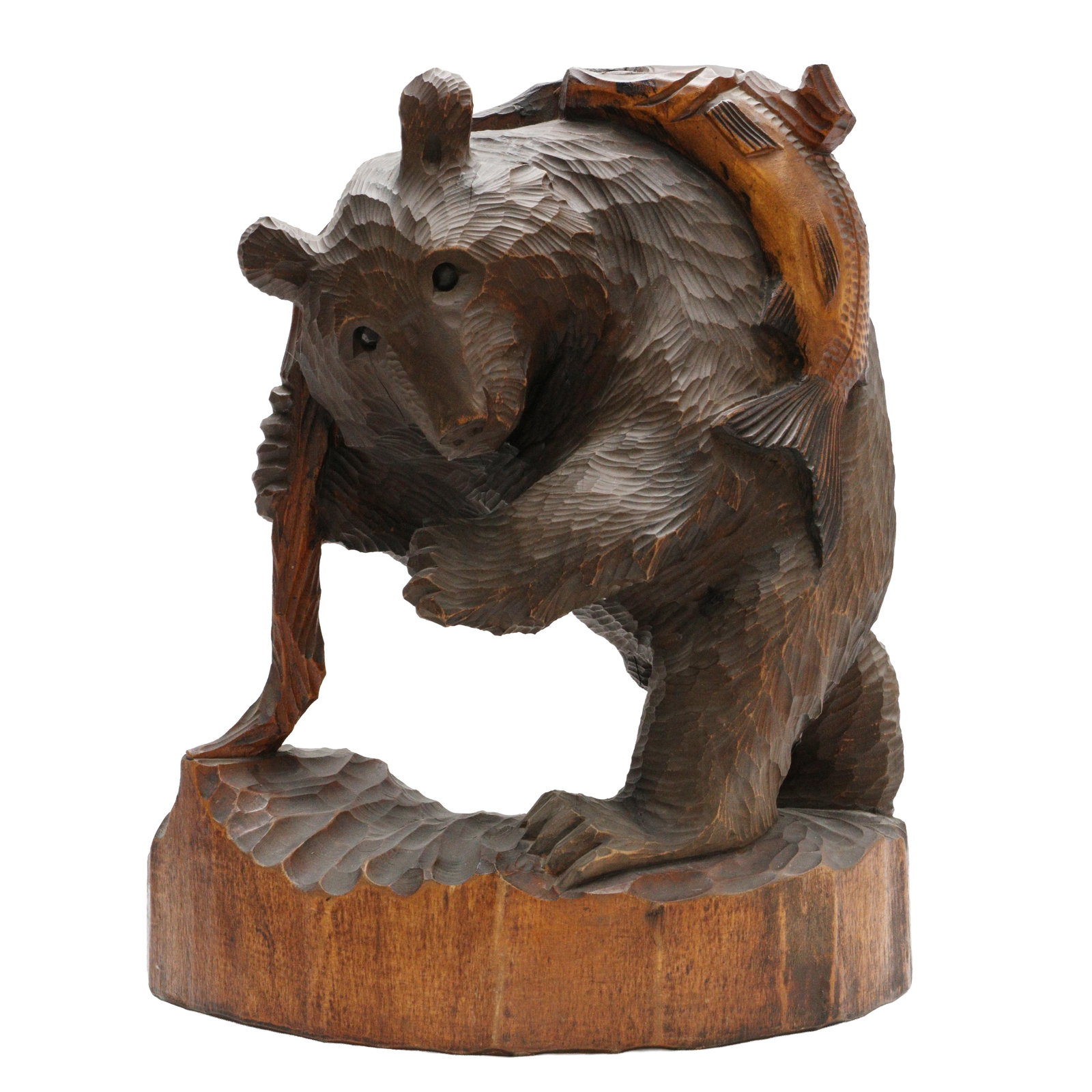 A Japanese Ainu wood 'Kibori Kuma' bear sculpture, Hokkaido, 20th century: The robustly carved wood figure in the form of a large bear leaning against a trunk with a salmon on his back Size:(38cm high) Qty: (1) Provenance: Private collection, bought in Japan between 1992 and